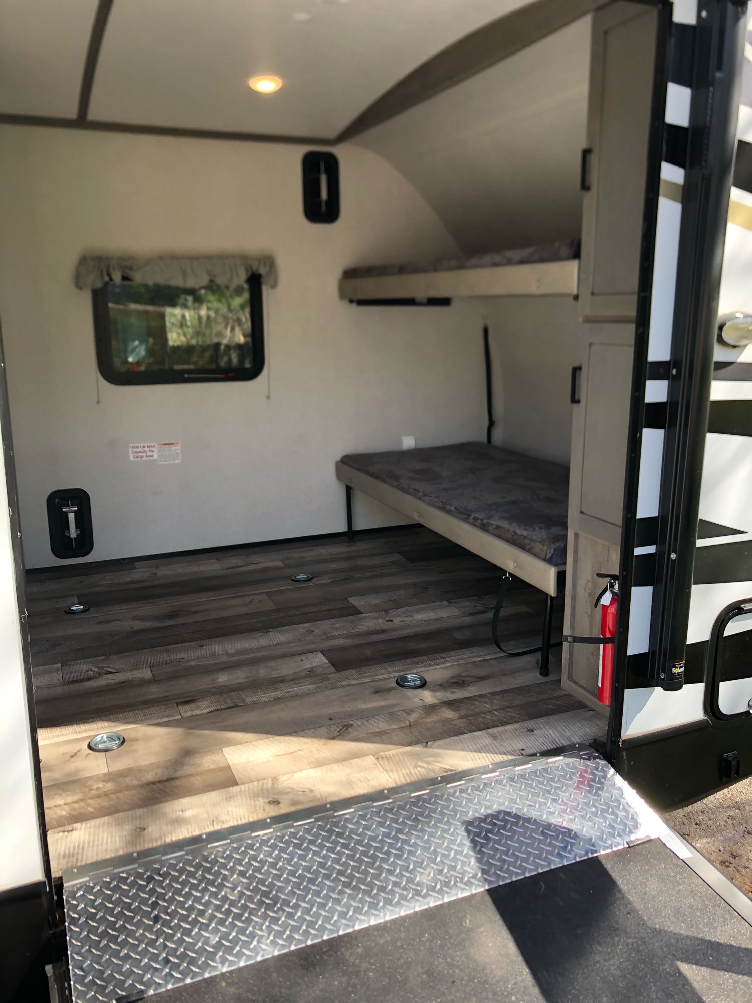 Explore this RV rental's versatile interior with bunk beds, durable wood-look flooring, and ample cargo space via a ramp.. Keystone Outback Ultra-Lite 2021