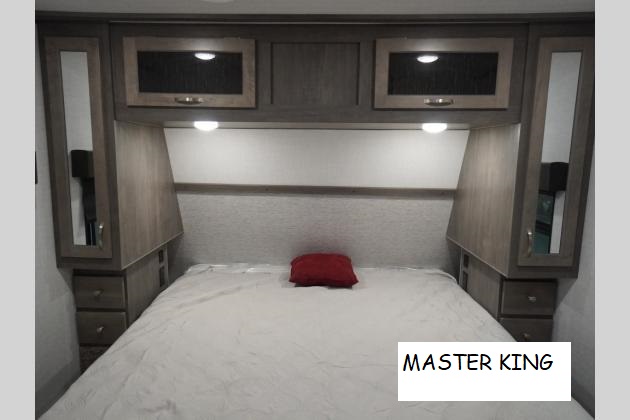 Comfortable RV rental master bedroom with king bed, overhead storage, and built-in nightstands.. Forest River ALTA 315 2021