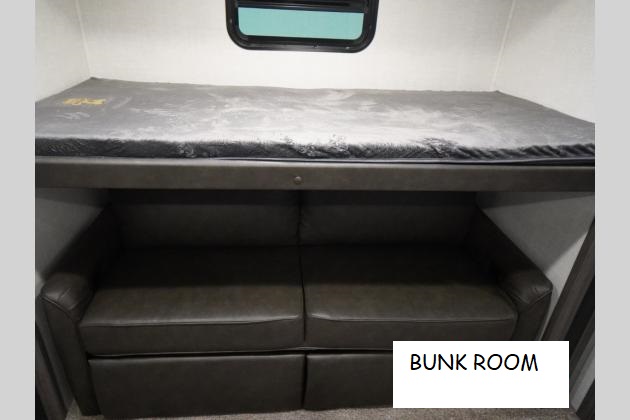 Efficient RV rental bunk room with a top bunk bed over a sofa, maximizing sleeping and living space.. Forest River ALTA 315 2021