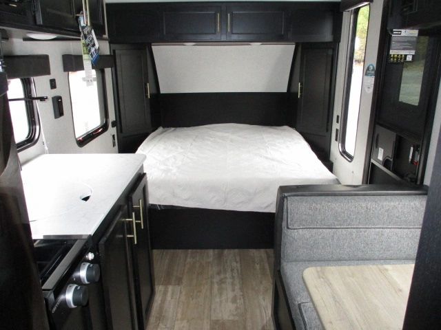 This RV rental interior offers a comfortable bed, compact kitchen, and dinette. Perfect for your next road trip.. Forest River Cherokee Wolf Pup 2021