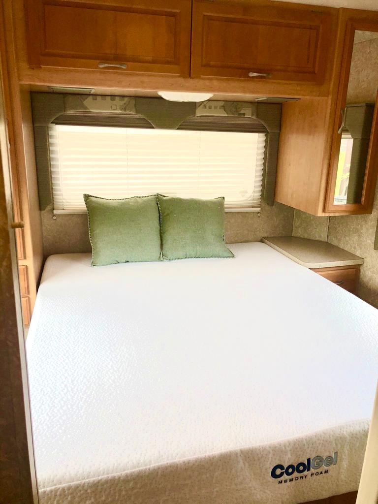 Cozy RV rental bedroom featuring a CoolGel memory foam mattress, window, and wood cabinetry for a comfy trip.. Thor Motor Coach Four Winds Five Thousand 2007