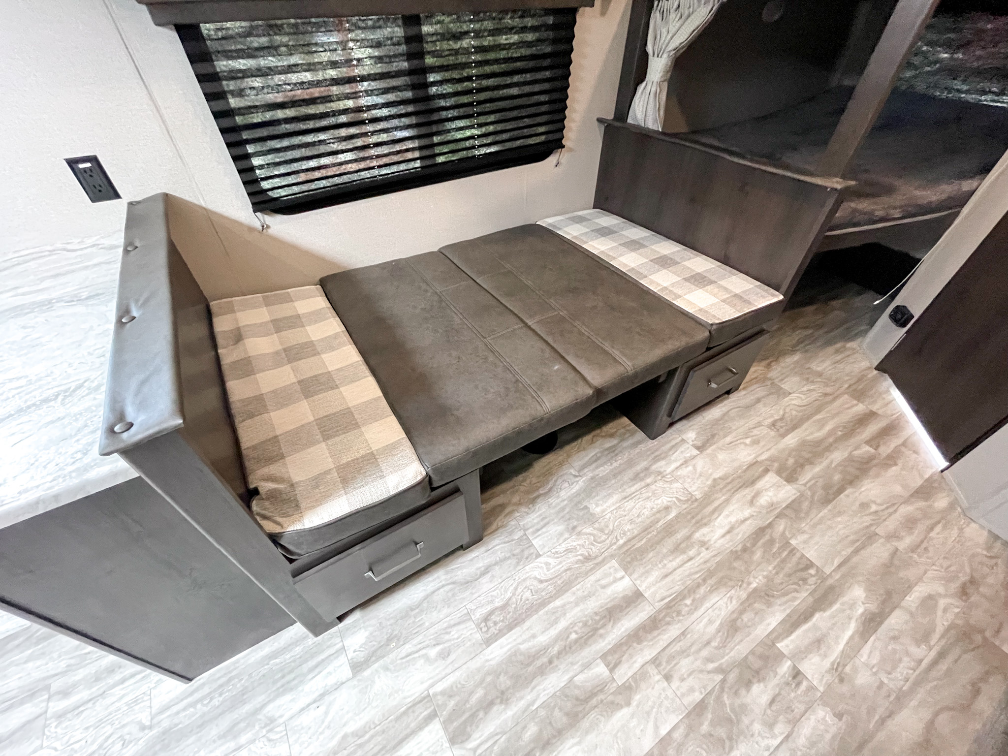 This RV rental interior features a versatile dinette that converts to a bed, storage drawers, and bunk beds.. Grand Design Other 2021