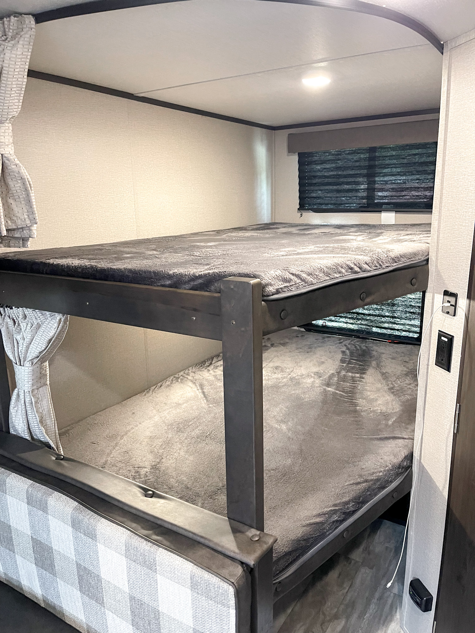 Cozy RV rental interior with comfortable bunk beds, perfect for family camping adventures. Features lights, blinds, and soft bedding.. Grand Design Other 2021