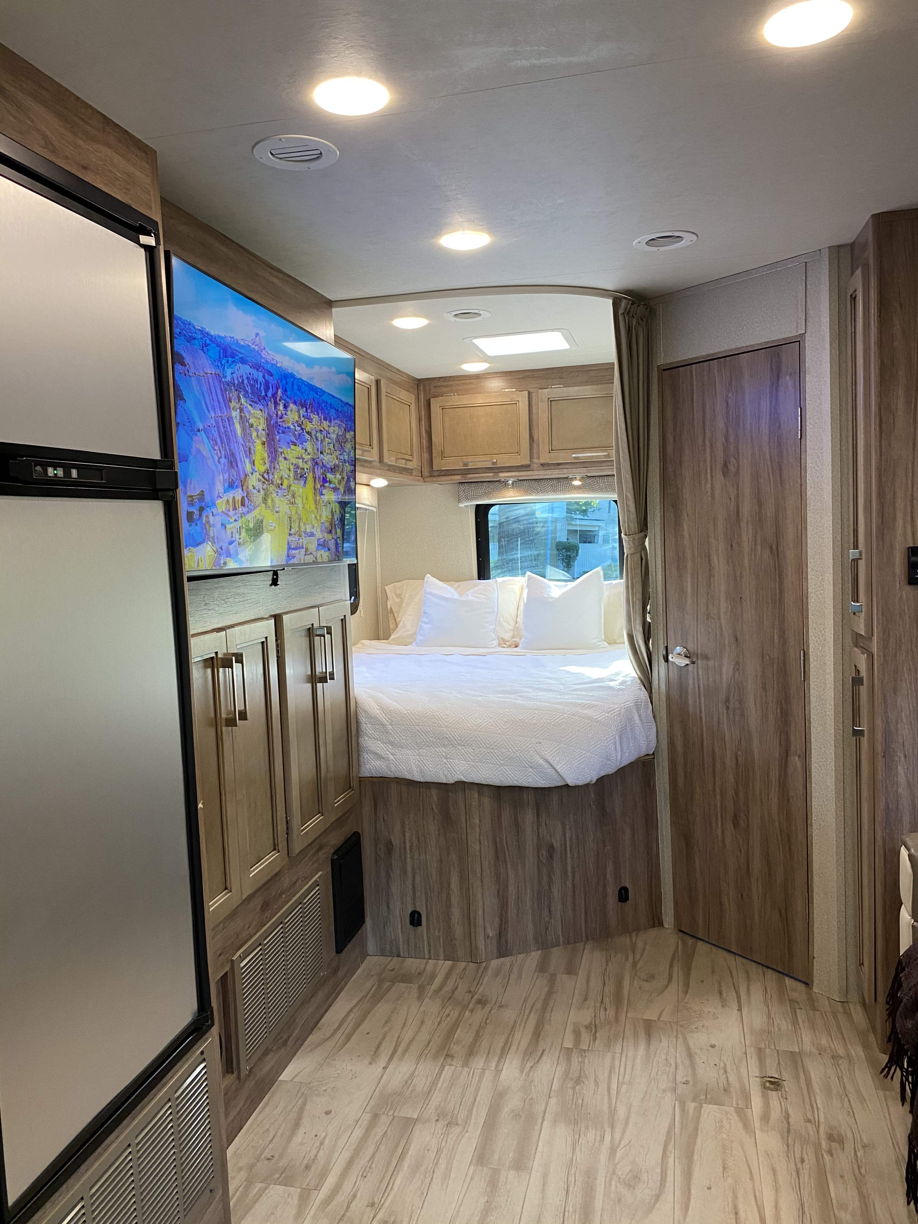 This RV rental offers a comfortable interior with a bed, large TV, fridge, and wood-look finishes.. Entegra Coach Odyssey 2019