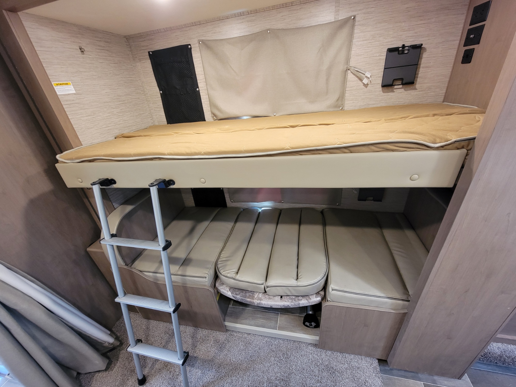 RV rental interior: bunk bed with ladder over versatile dinette table and seating. Ideal for family travel.. Thor Motor Coach Chateau 2022