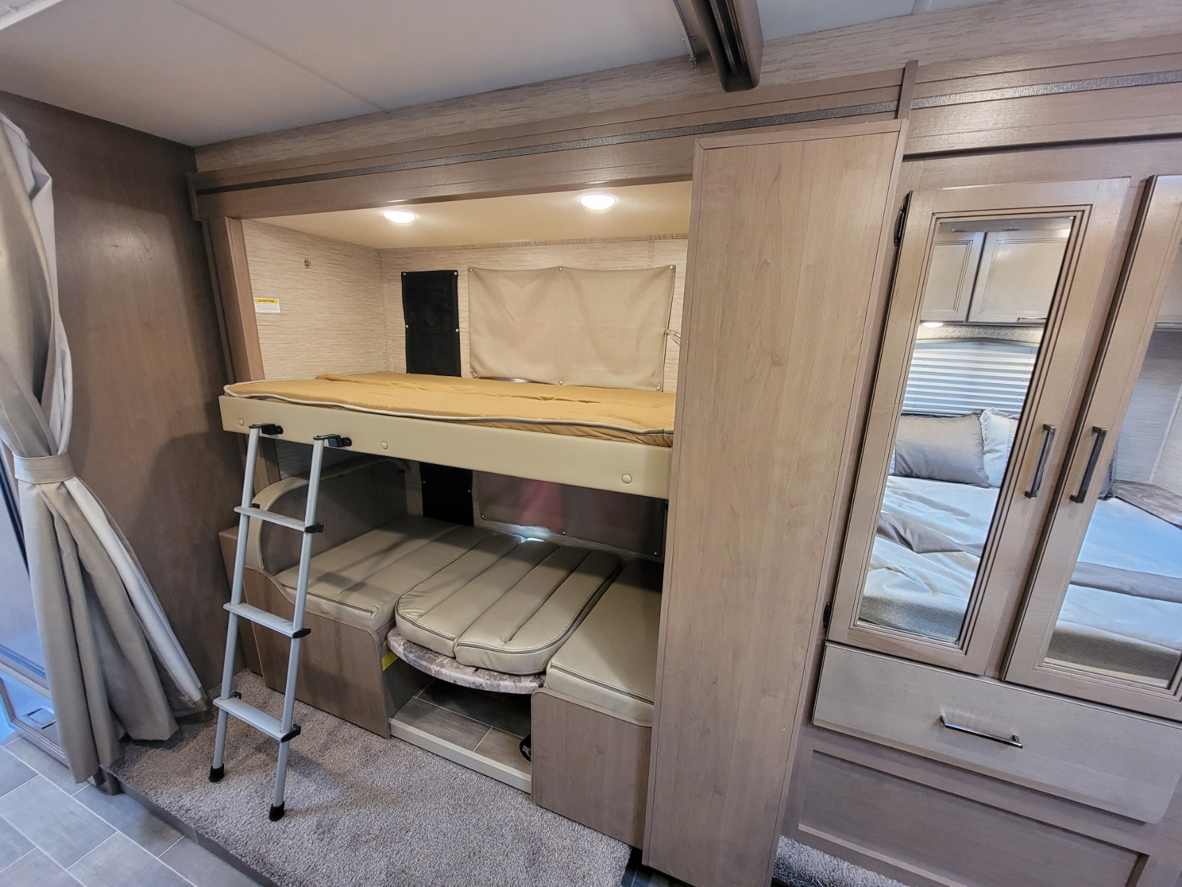 Compact RV rental interior, featuring bunk beds, convertible seating, and a wardrobe. Perfect for family sleeping.. Thor Motor Coach Chateau 2022