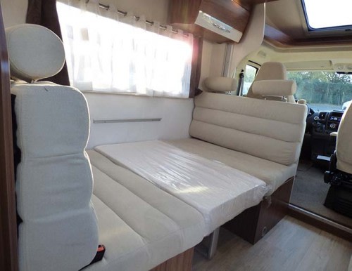RV rental interior: light-colored seating converts to a bed/table. Spacious dinette and front cabin. Clean & modern.. Pilote P696 S ESSENTIEL 2024