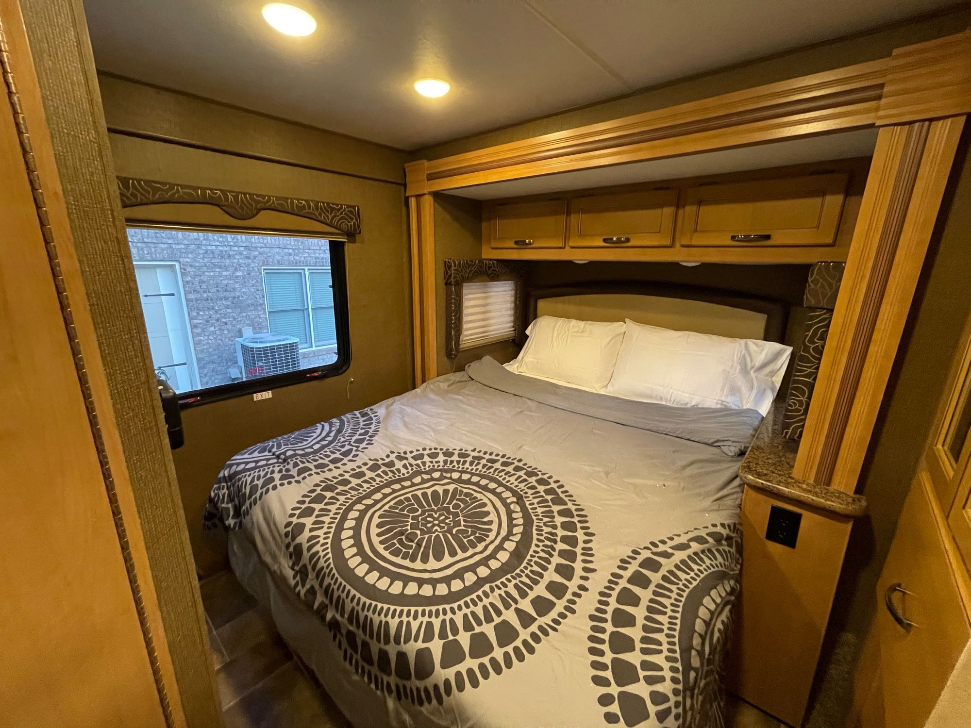 Comfortable RV rental bedroom with a cozy bed, overhead storage, and window view for a relaxing trip.. Other Freedom Elite 2017