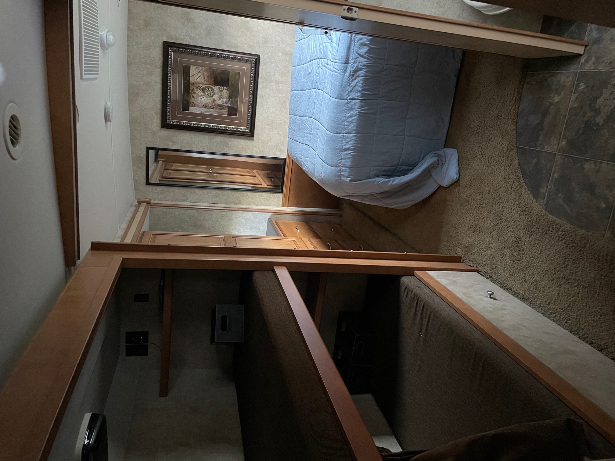 Explore this RV rental's interior: a comfortable bedroom with a blue comforter and a separate bunk bed area for extra sleeping.. Itasca Sunstar 2012