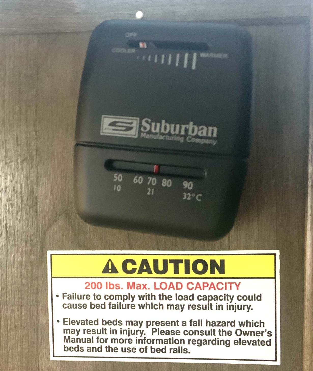 RV rental: A Suburban thermostat and a caution sign for a bed's 200 lbs max load capacity & elevated bed fall hazards.. Pioneer BH170 2021