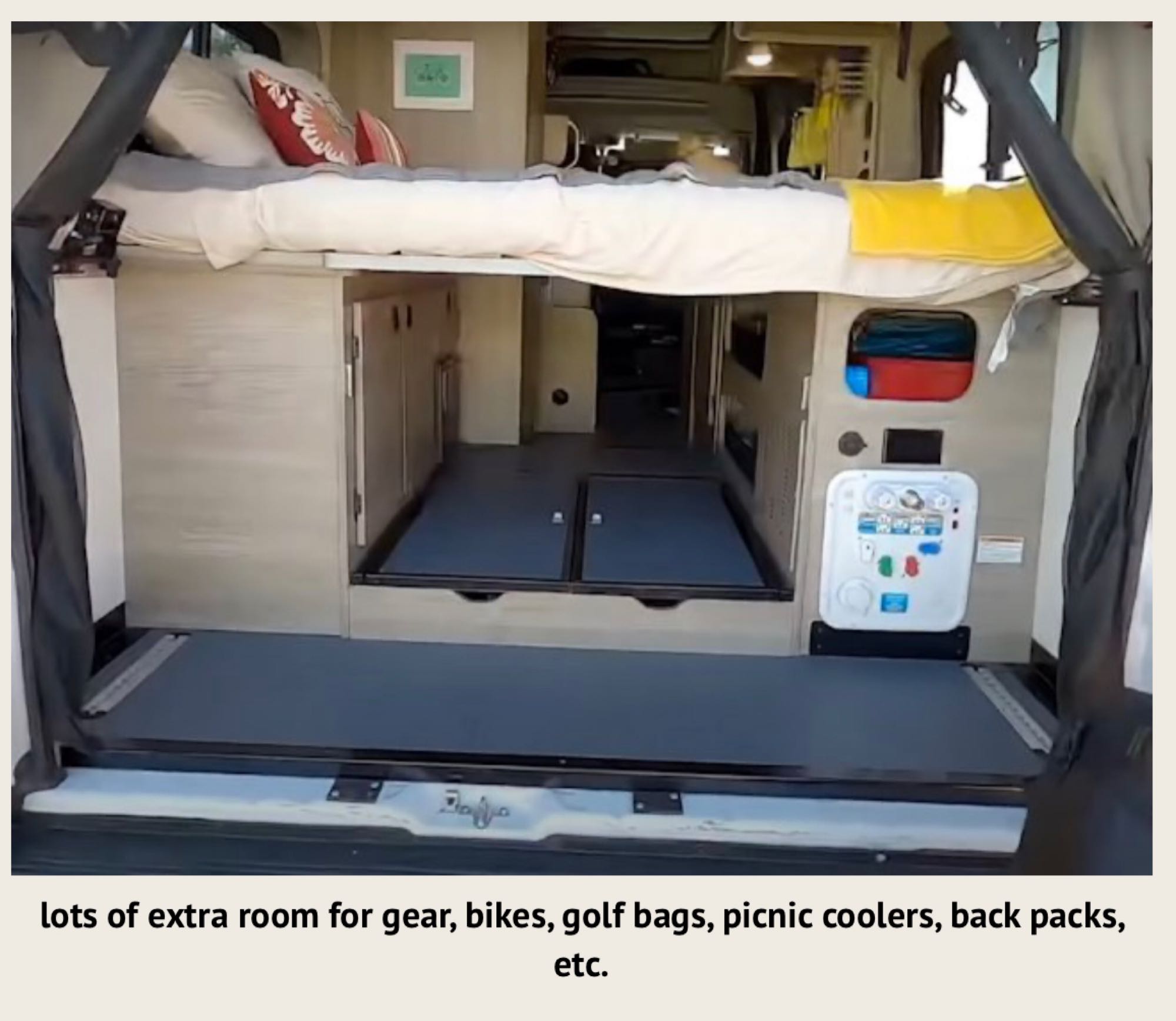 An RV rental's rear cargo area with a lowered floor, showing a bed above, perfect for gear.. Winnebago Solis 2021
