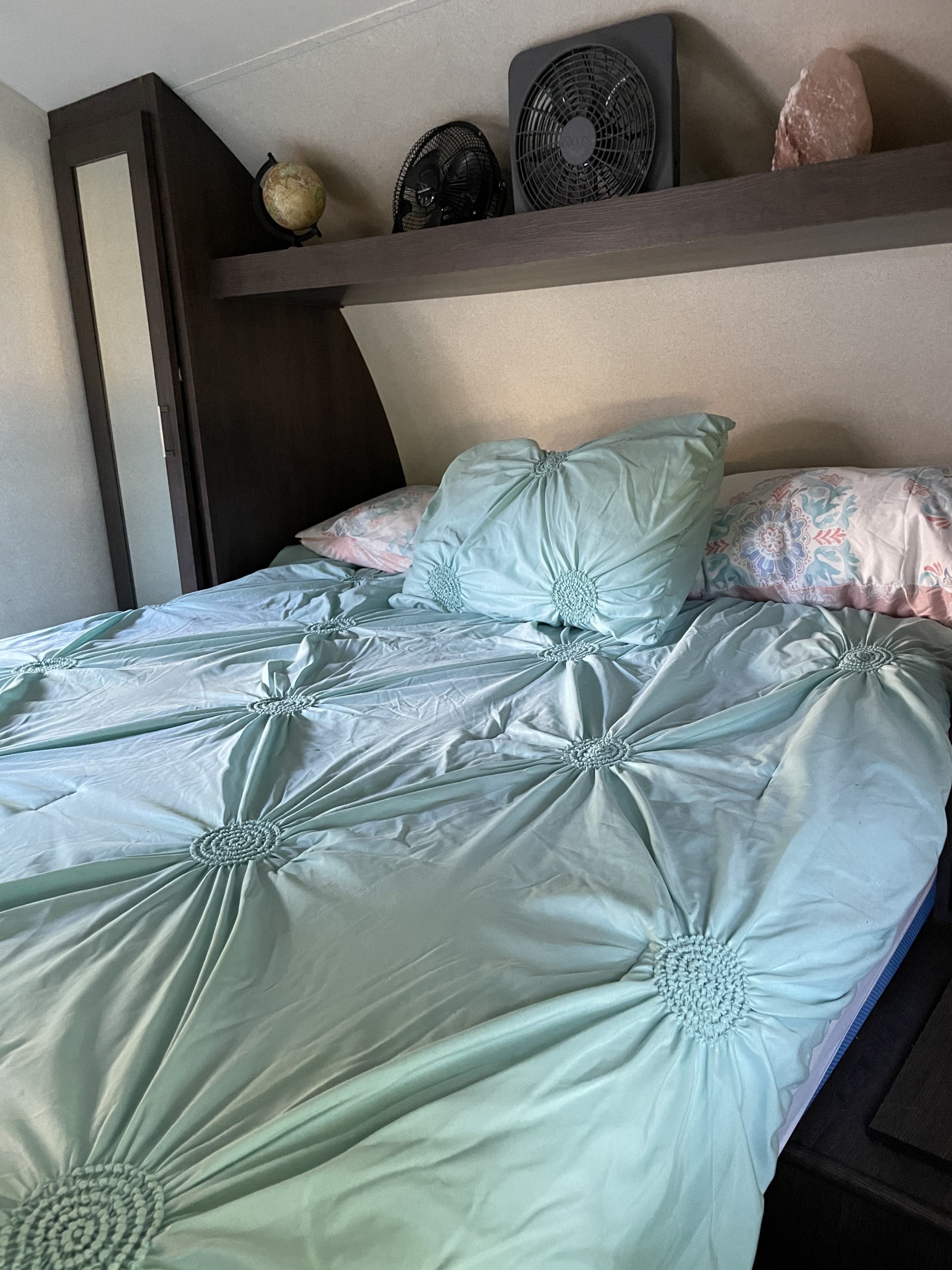 RV rental: Cozy bedroom with blue comforter, pillows, and overhead shelf. Fans, globe, & salt lamp visible.. Forest River Other 2018
