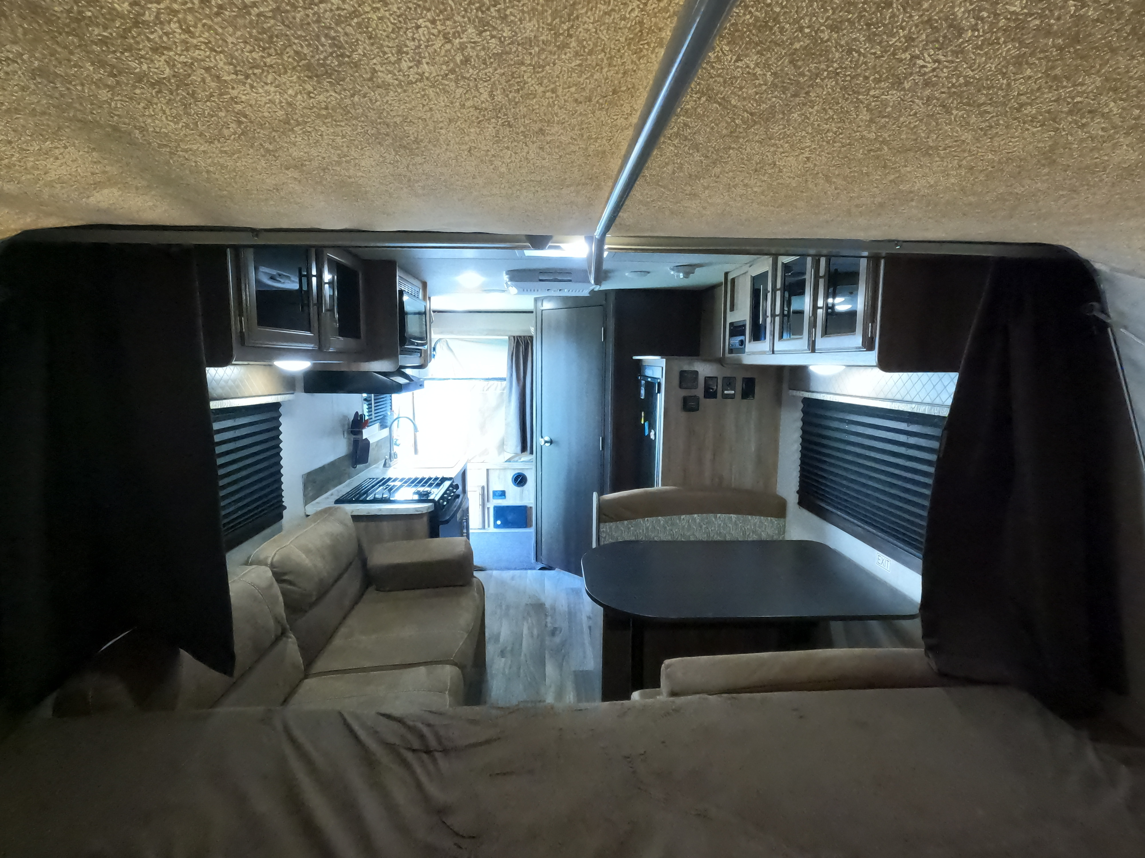 Inside a modern **rv rental**, featuring a full kitchen, cozy sofa, and dining area. Ready for road trips!. Jayco Jay Feather 2018