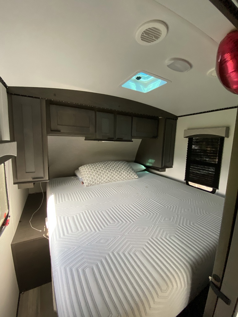 Relax in this comfortable RV rental bedroom, featuring a large bed, overhead cabinets, and a skylight.. Cruiser Rv Corp Cruiser 2021