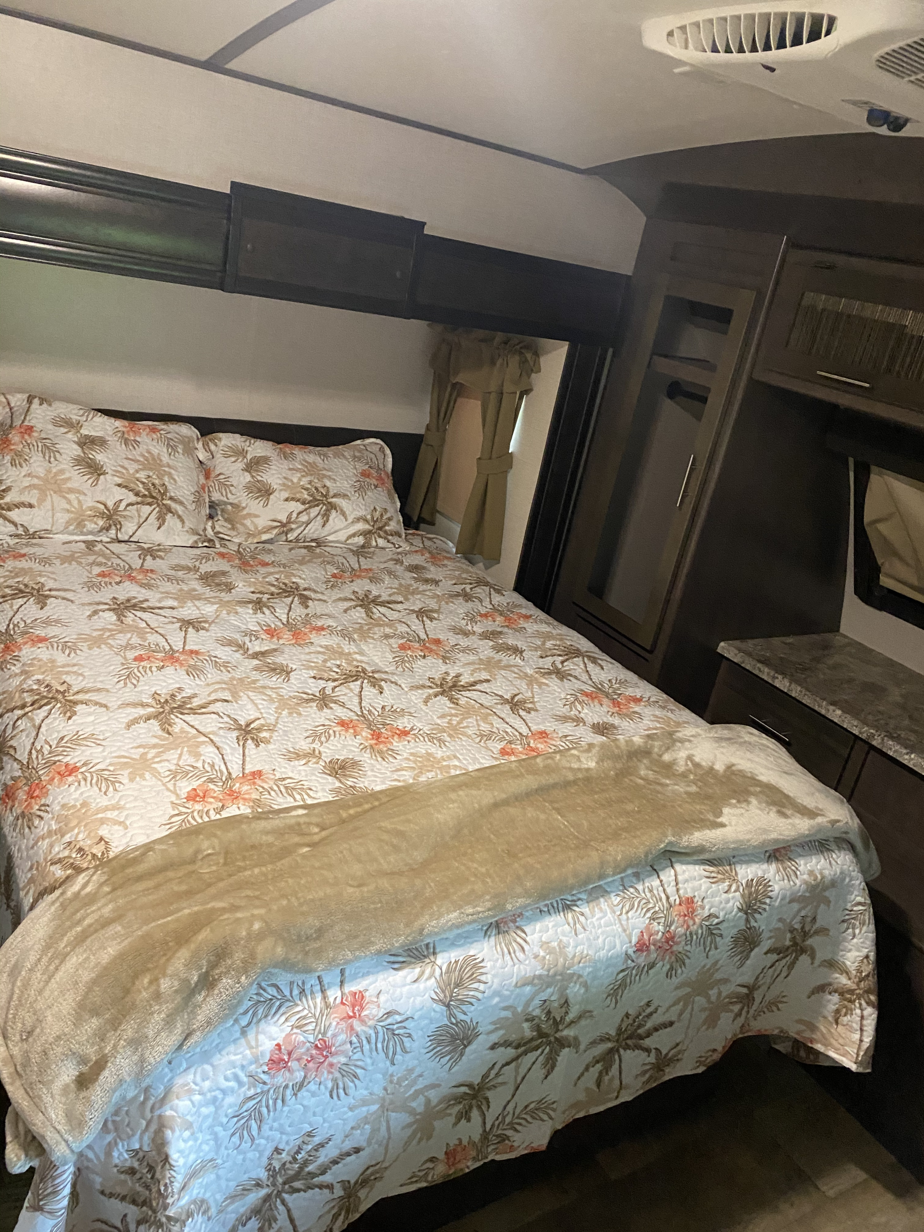 Cozy RV rental bedroom with tropical palm tree bedding & built-in storage. Ideal for a comfortable adventure!. Crossroads Sunset Trail Reserve 2018