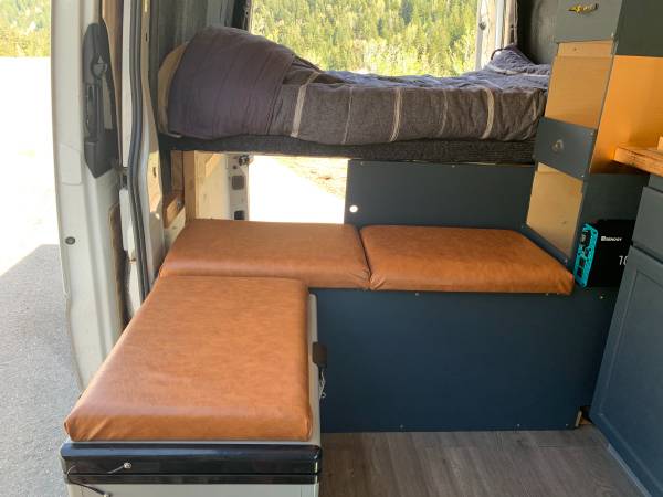 Experience comfort in this RV rental! Custom van interior with elevated bed, versatile seating, & portable fridge.. Dodge Sprinter Van 2008