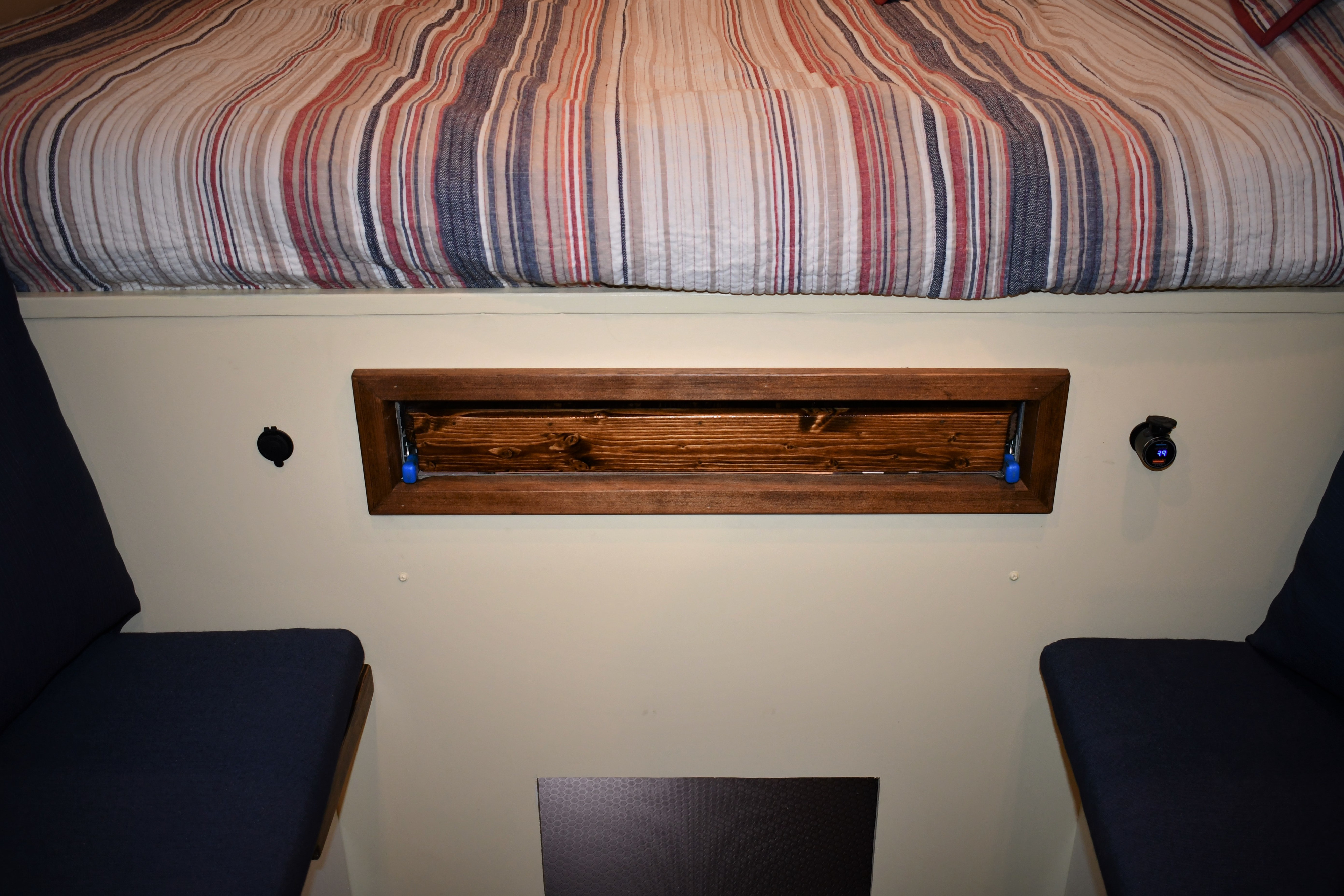 RV rental interior: striped bed, wood storage, USB charge port, & comfy seating.. Other Other 2021