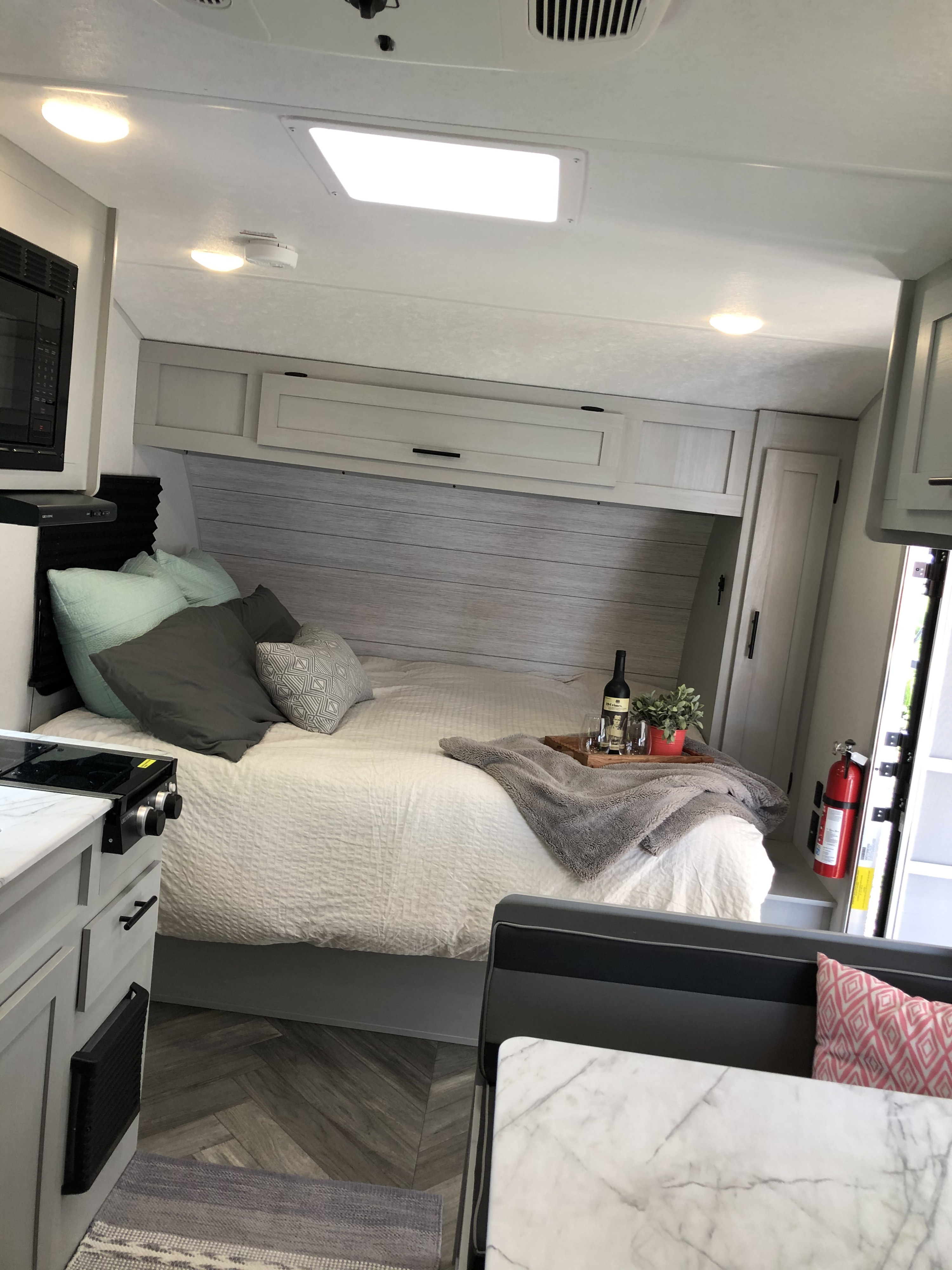 Modern RV rental interior with a bed, small kitchen, and dining area. Clean and comfortable space for travel.. Forest River Other 2021