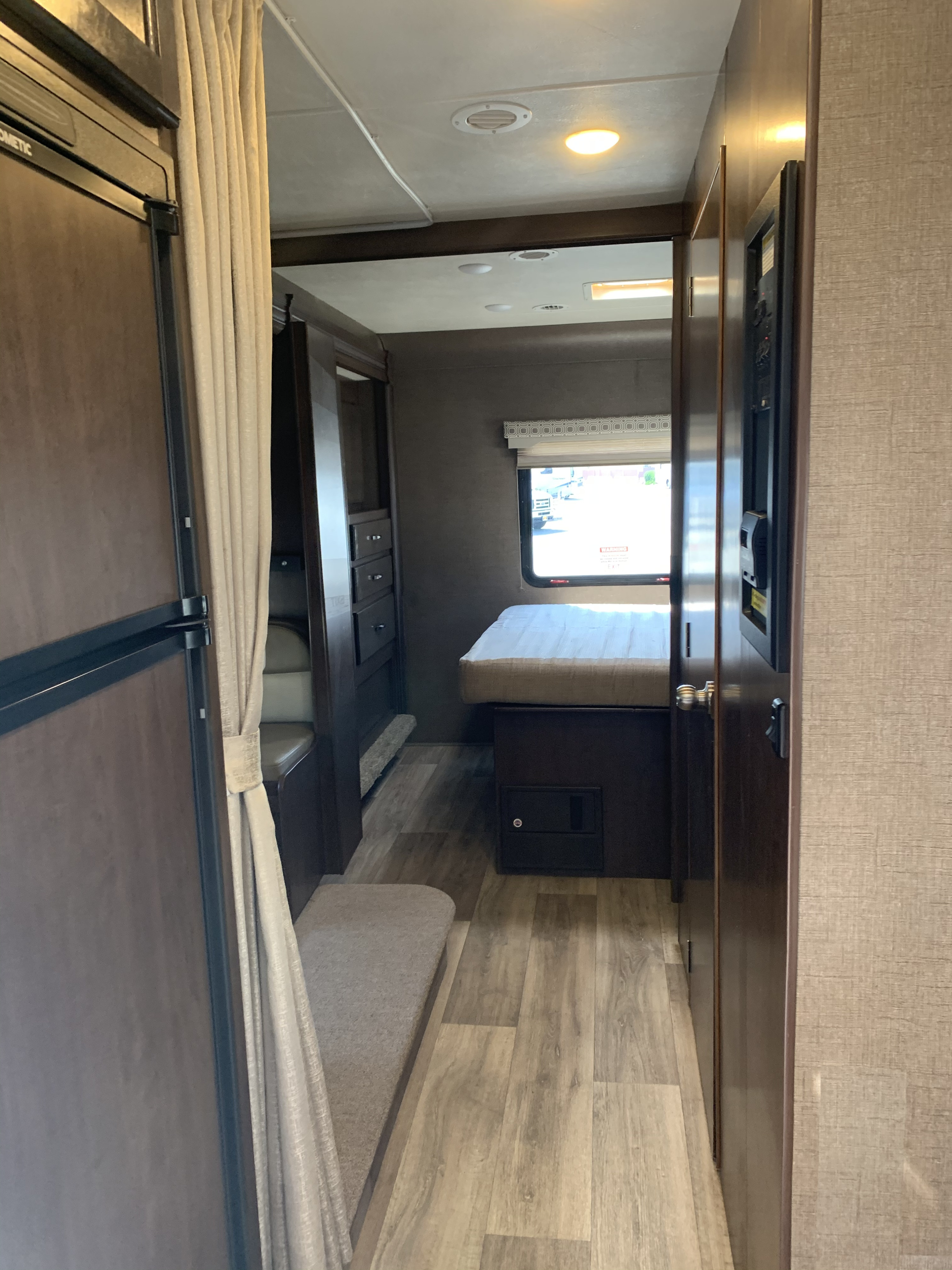 rv rental: Interior hallway view showing kitchen fridge, bedroom with bed, window, and built-in storage.. Four winds Four Winds 2020