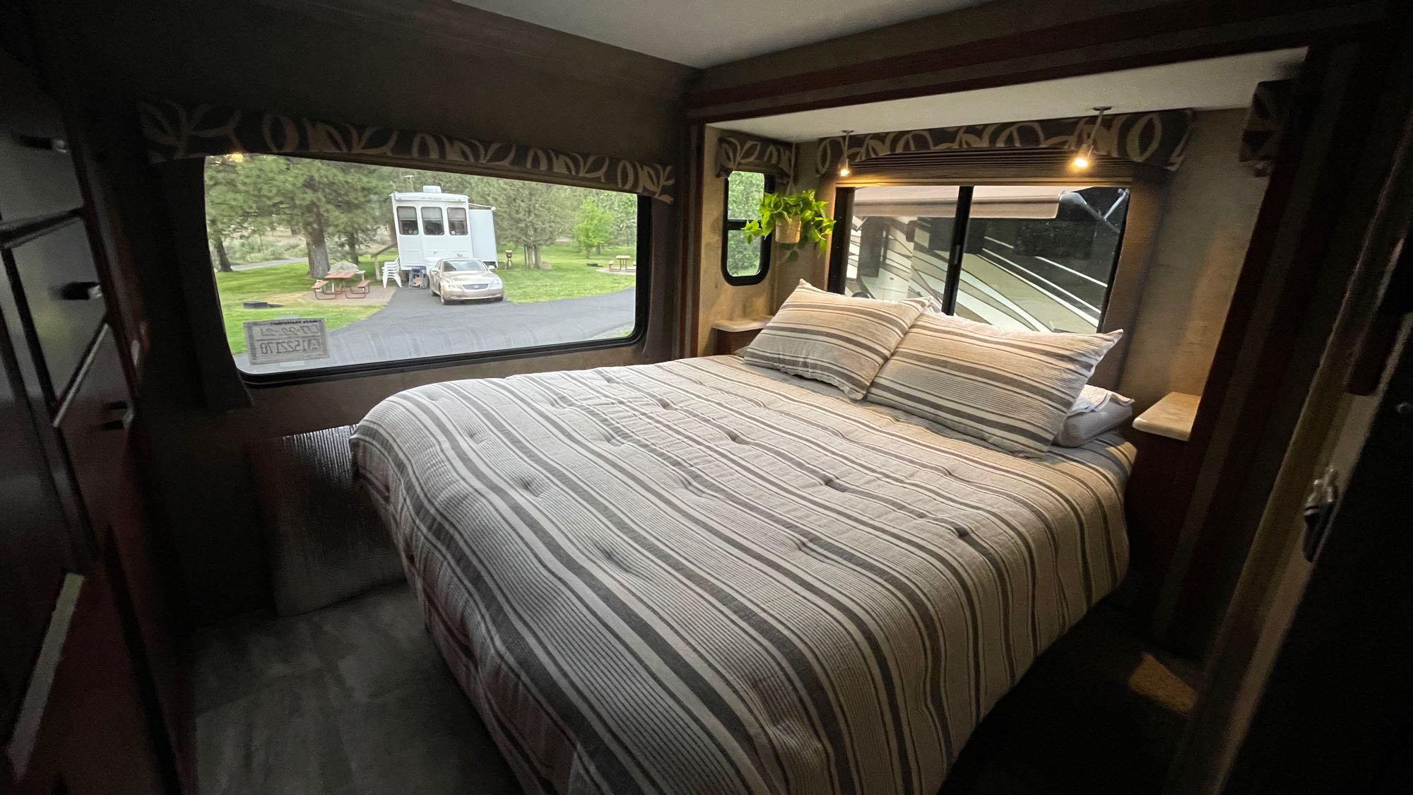 Cozy RV rental bedroom with striped bedding and a scenic view of the campground, perfect for a relaxing stay.. Forest River Forester 2016