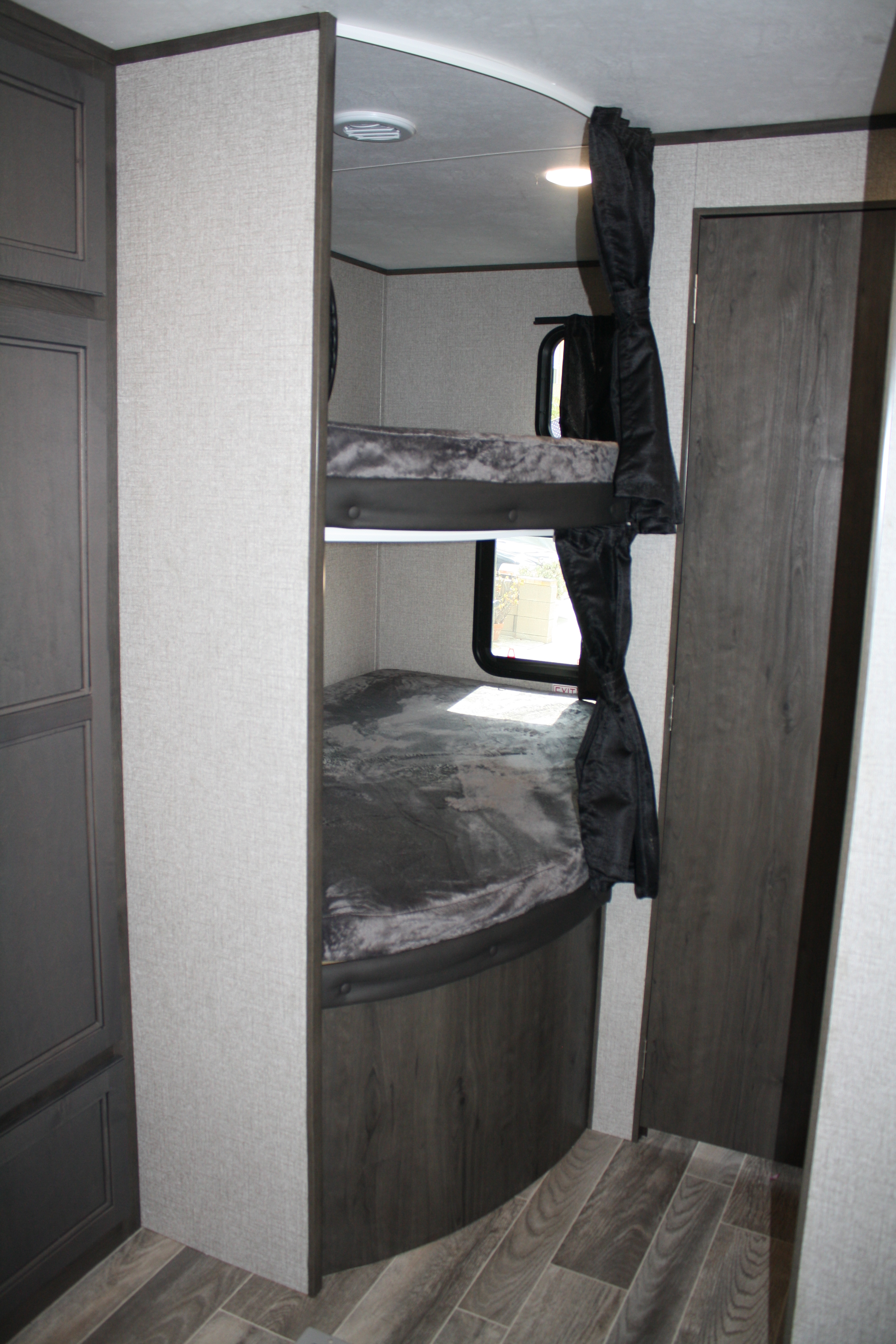 RV rental: Inside a modern travel trailer showing two comfortable bunk beds with windows and curtains, ideal for family trips.. Jayco Jay Flight 2021