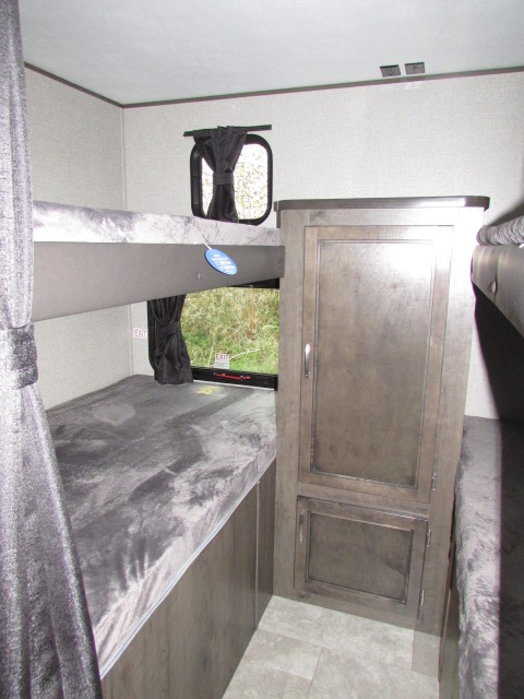 RV rental bunk room features upper & lower bunks with grey mattresses, a storage cabinet, and windows with outdoor views.. Jayco Jay Flight SLX 2021