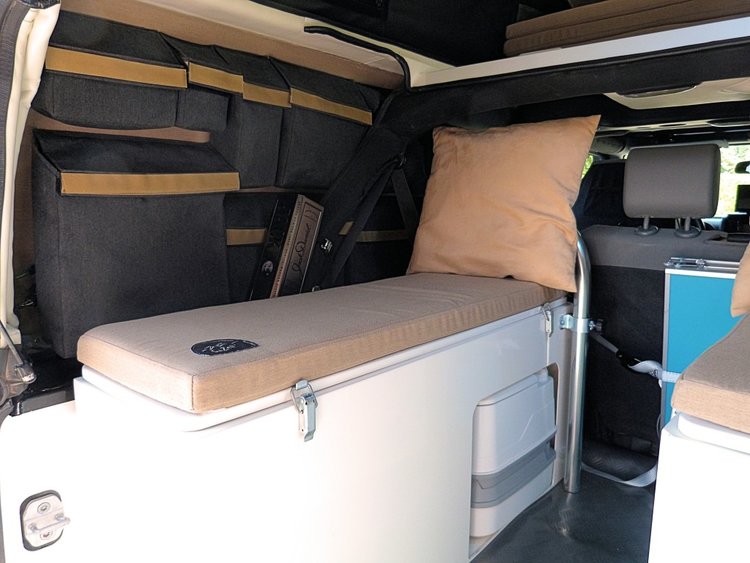 RV rental interior: Bench seating, wall storage, and a hidden portable toilet maximize space for your travel adventures.. Jeep Rubicon Pop-top 2016
