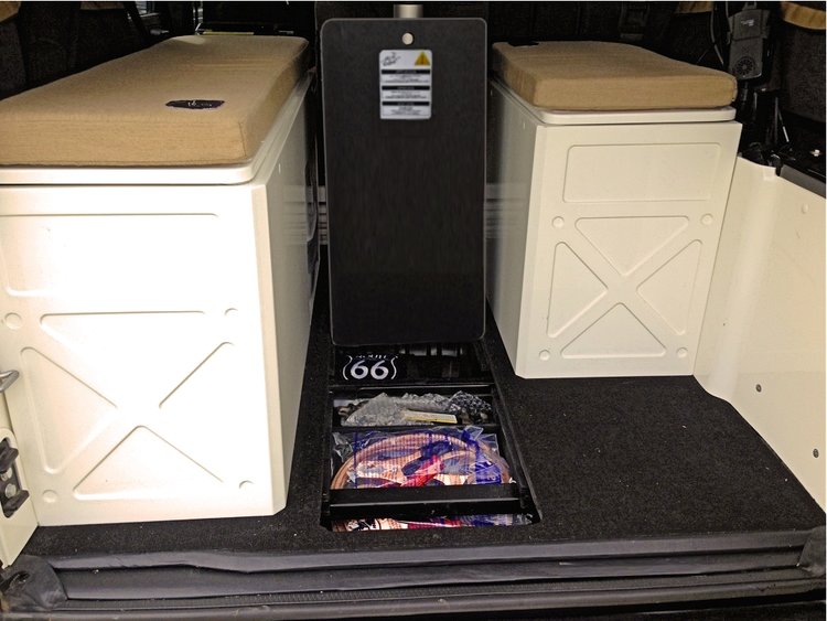 RV rental: Camper rear shows custom white storage units with tan cushions (for bed), plus integrated floor storage.. Jeep Rubicon Pop-top 2016