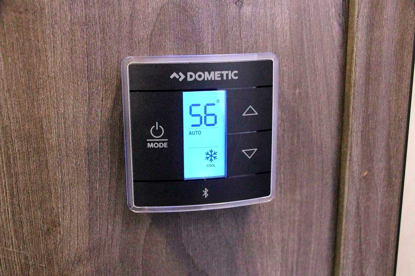 A Dometic digital RV thermostat, set to 56°F in cool mode. A common feature for climate control in an rv rental.. Coachmen Leprechaun 2021