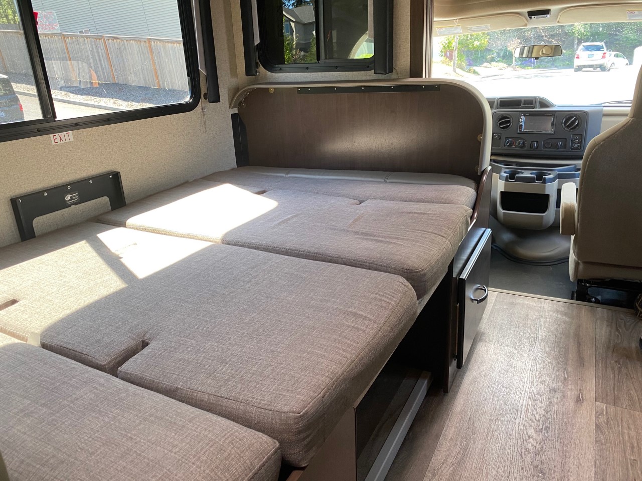 **RV rental interior**: A versatile camper van space with a convertible bed/lounge area and front cabin.. Thor Motor Coach Freedom Elite 2020