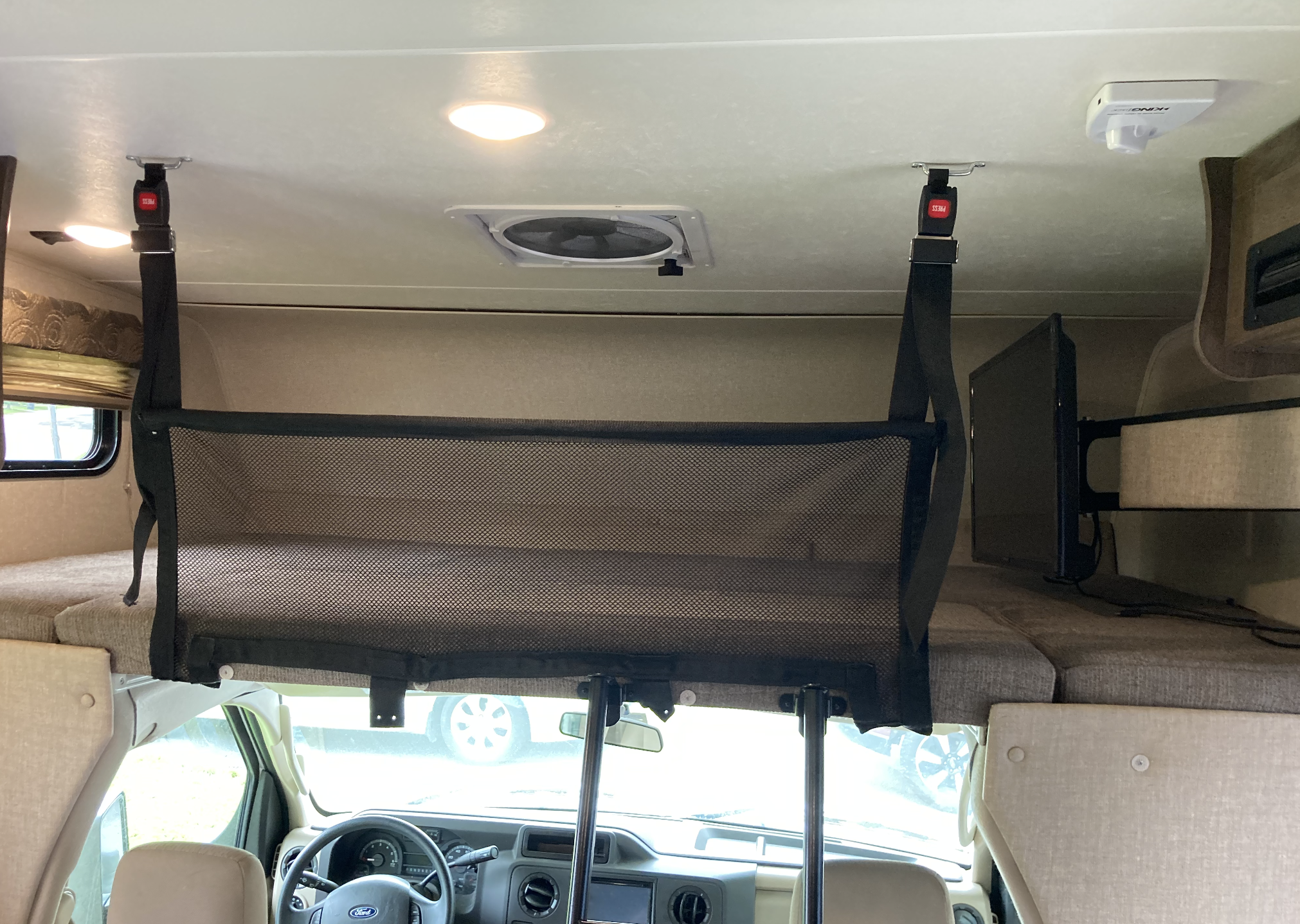RV rental interior: Overhead bunk with safety net, ceiling fan, lights, and antenna. Driver's cabin is visible below.. ford Other 2019