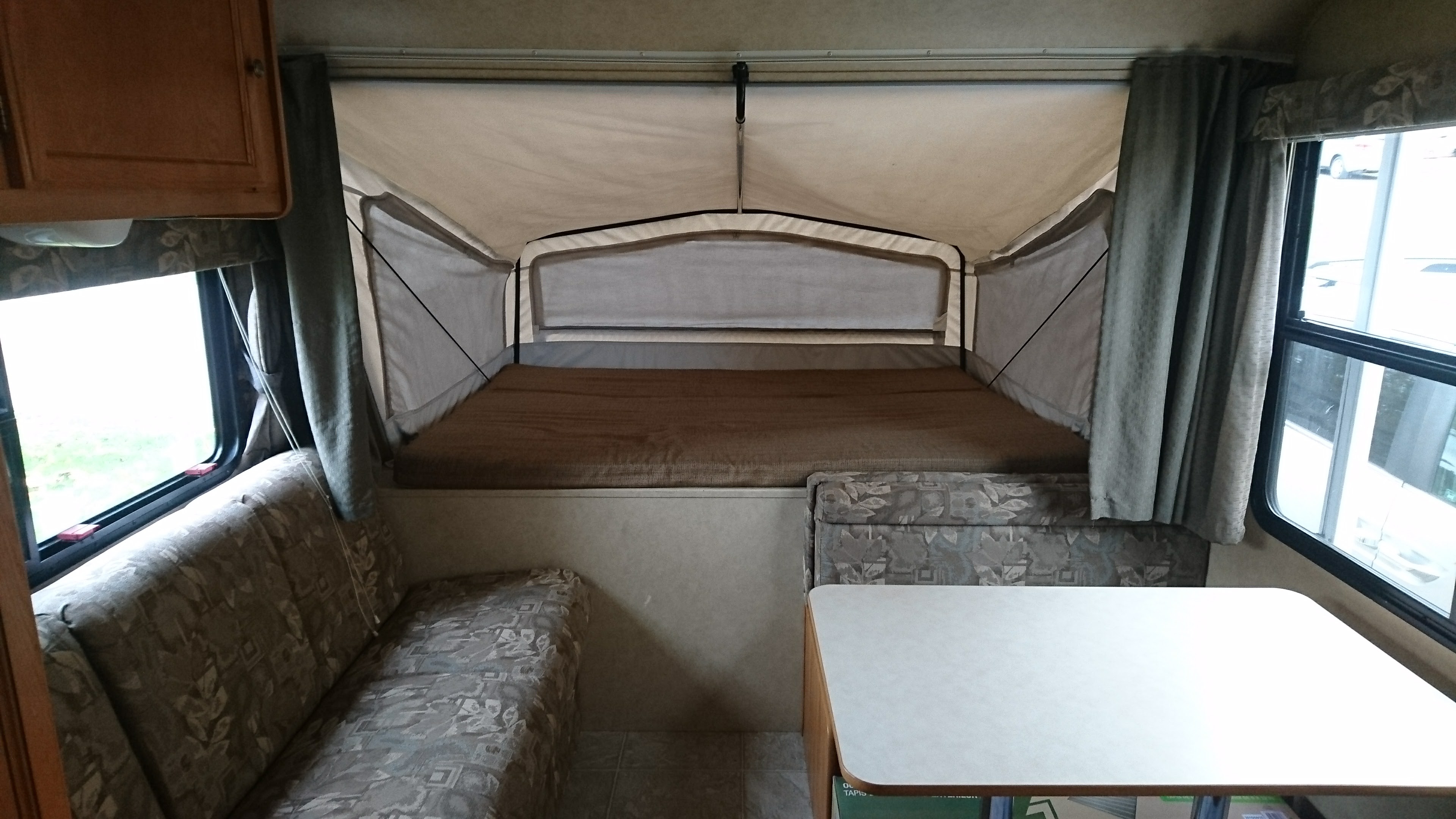 RV rental pop-up camper interior: Includes elevated bed, dinette, and large windows.. Starcraft Travel Star 2007
