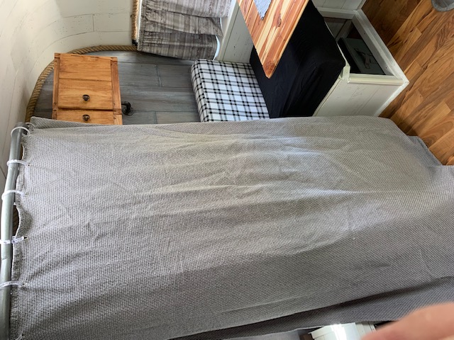 RV rental: Compact interior with a grey bed, wooden table, and clever storage. Ideal for travel comfort.. Nomad Rear fold 1962
