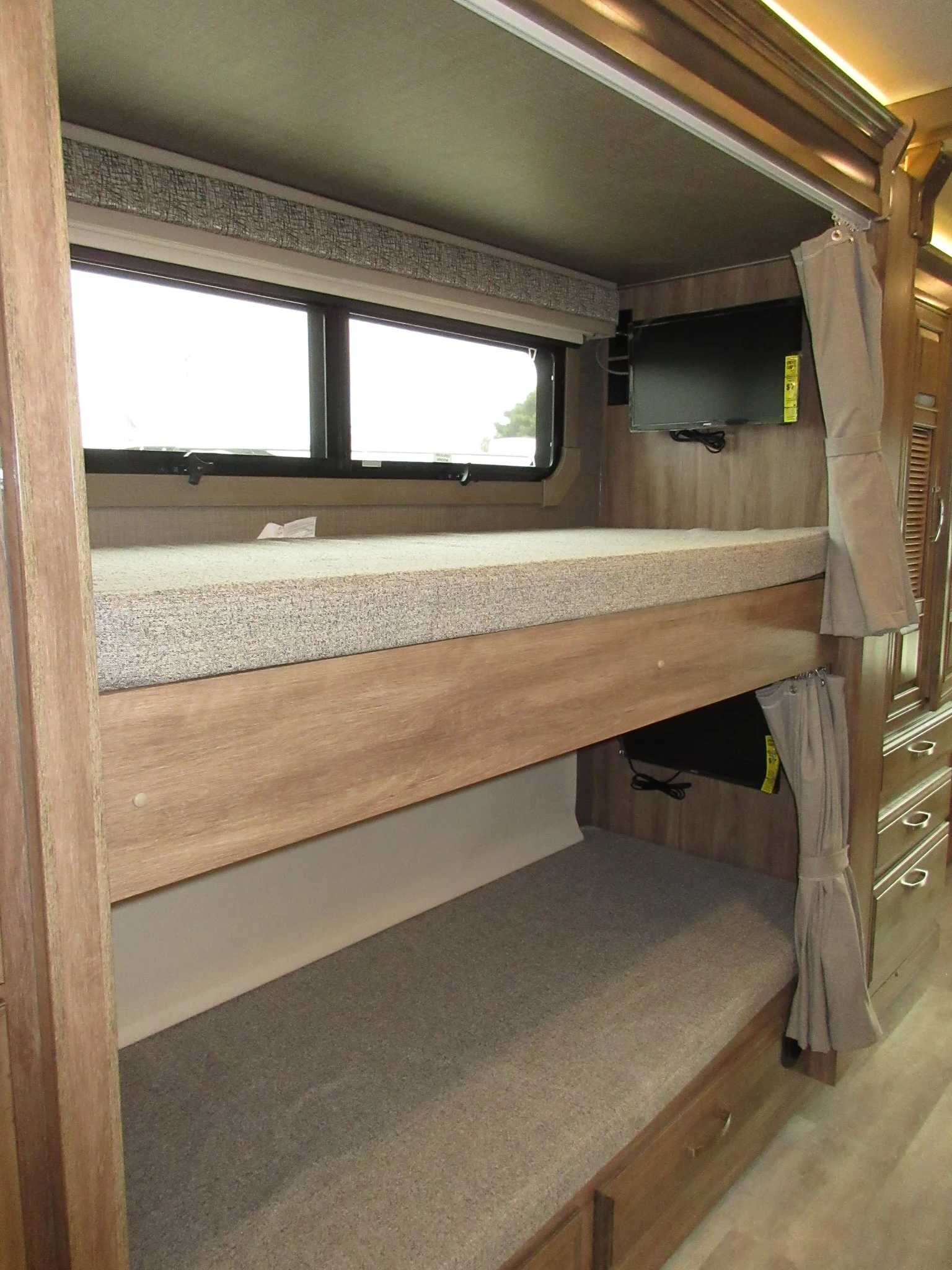 Inside an RV rental: double bunk beds with TVs, offering comfortable sleeping and entertainment options.. Jayco Seneca 2021
