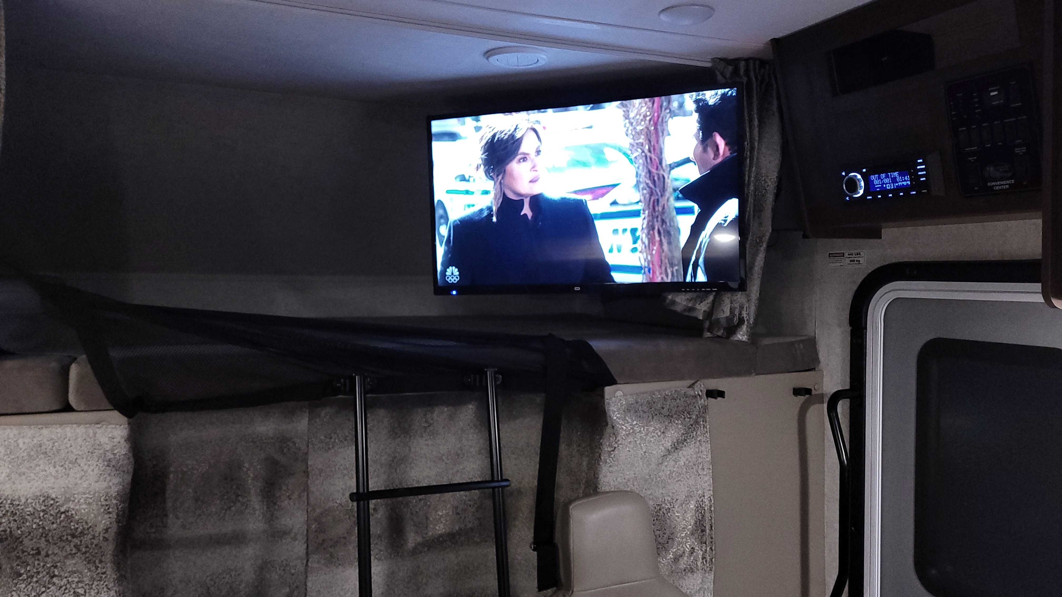 Inside an RV rental: TV, bunk bed with ladder, and media controls. Perfect for your next adventure.. Forest River Sunseeker 2019