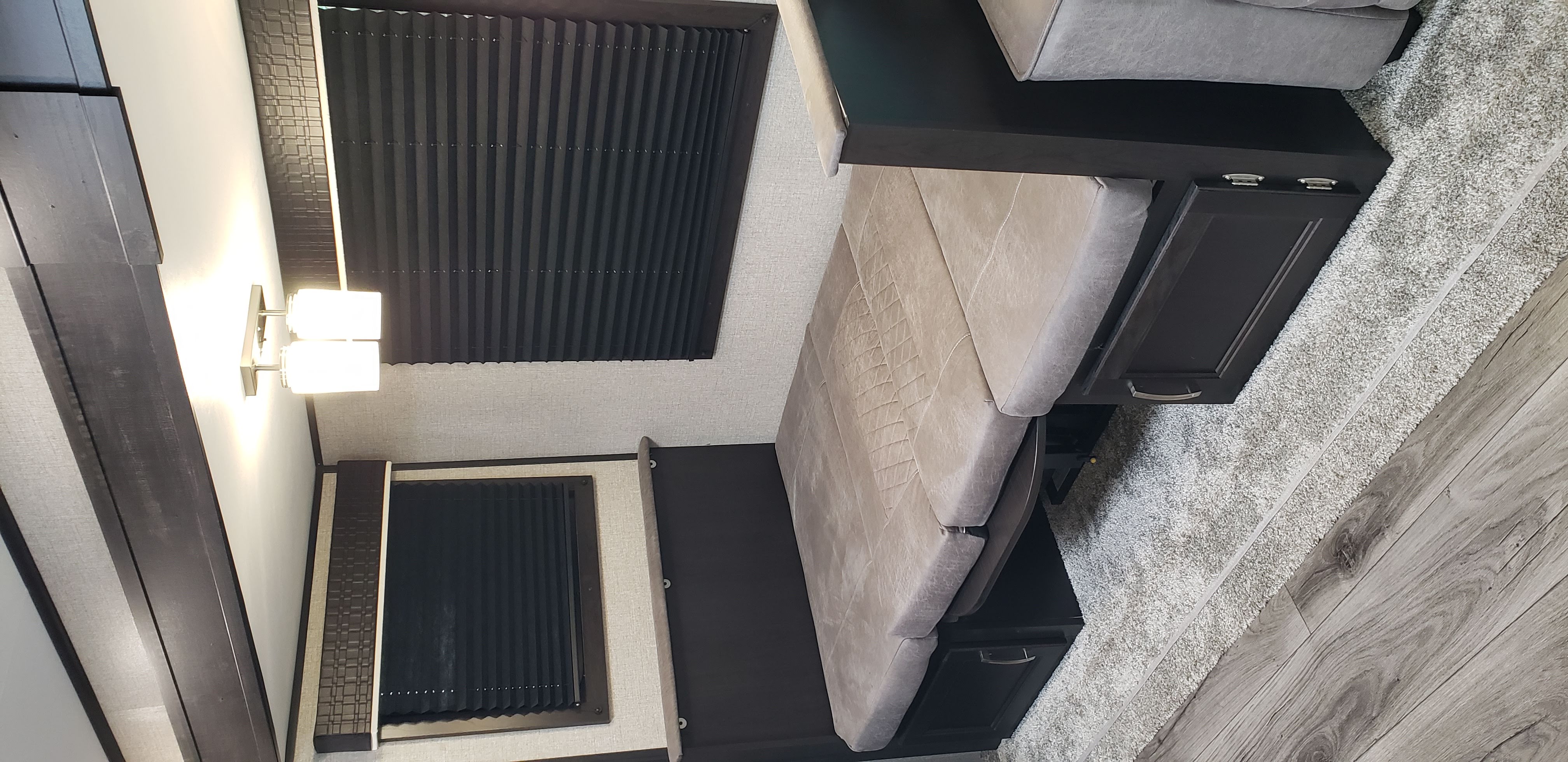 Cozy RV rental interior featuring a convertible dinette/sofa, dark cabinetry, and modern lighting for a comfortable travel experience.. Jayco Jay Flight 2021