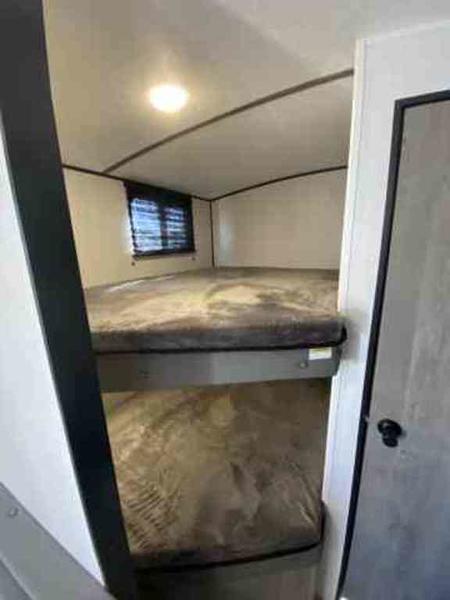 Inside an RV rental: comfortable bunk beds for extra sleeping space. Perfect for your next adventure.. Keystone Springdale 2021