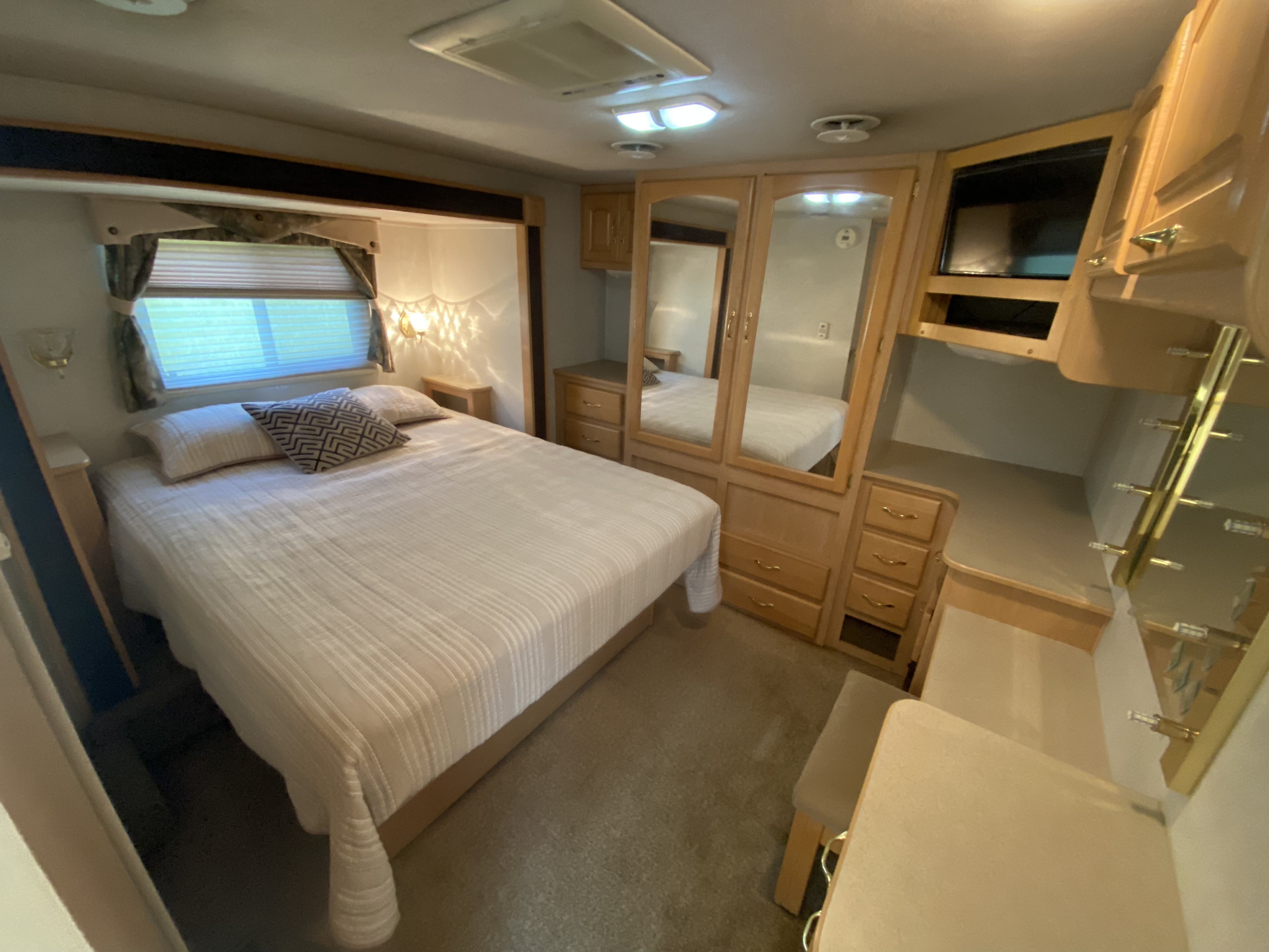 Large bedroom with storage, wardrobe, vanity, and television. Damon Challenger 2004