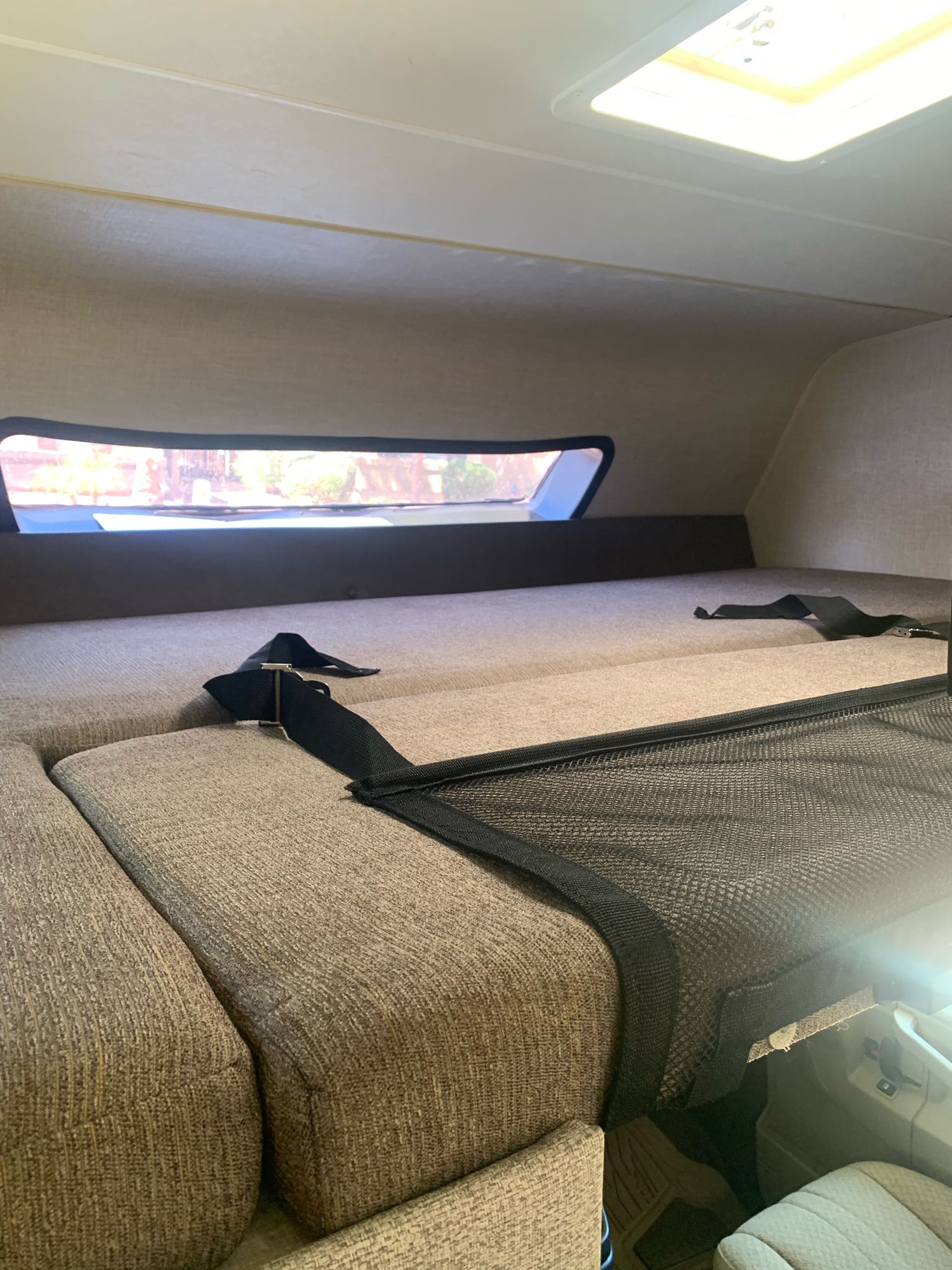 RV rental: Inside a cozy cab-over bunk with window, skylight, and safety net for comfortable sleeping.. Forest River Coachmen Leprechaun 2020