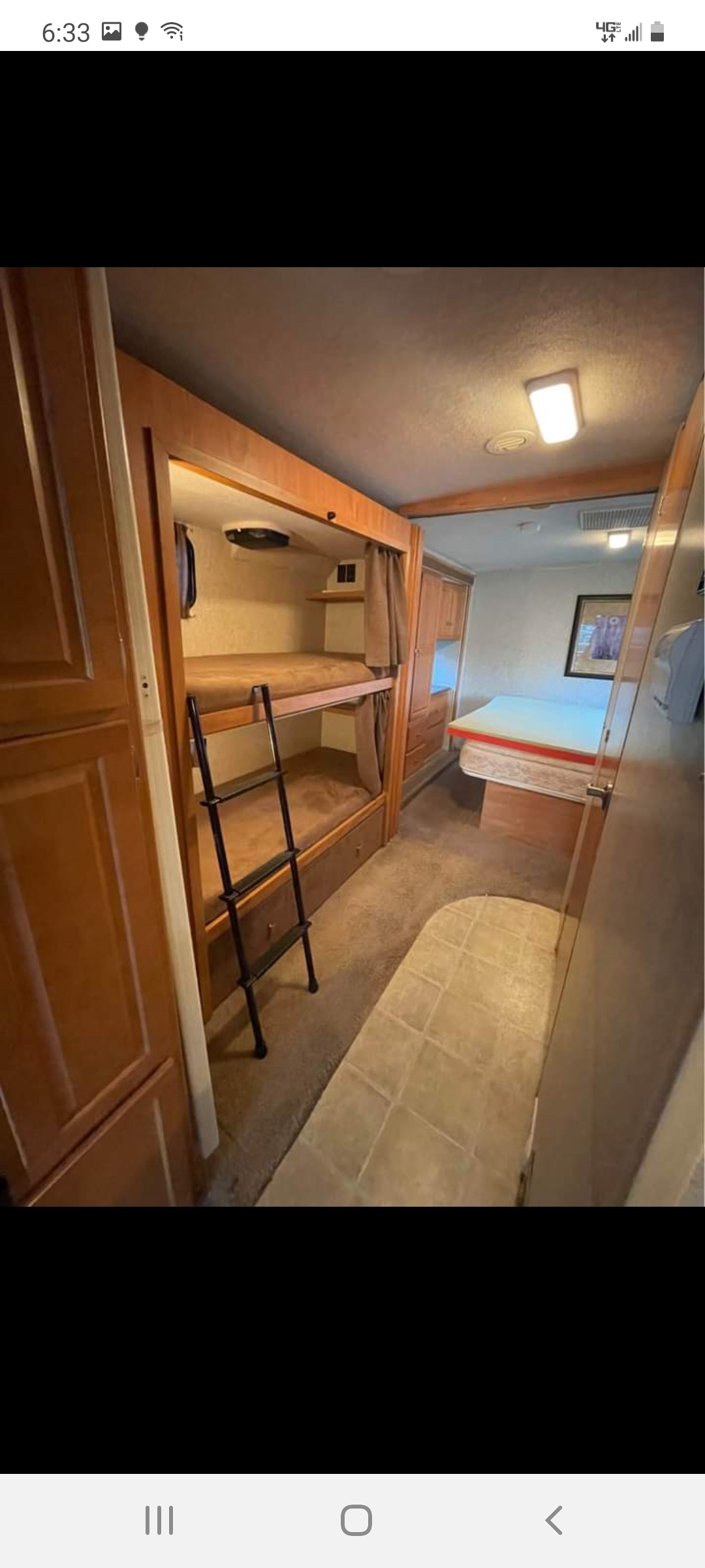 RV rental interior. Features bunk beds with ladder on left, transitioning to a master bedroom. Compact, comfortable travel space.. Winnebago Winnebago 2008