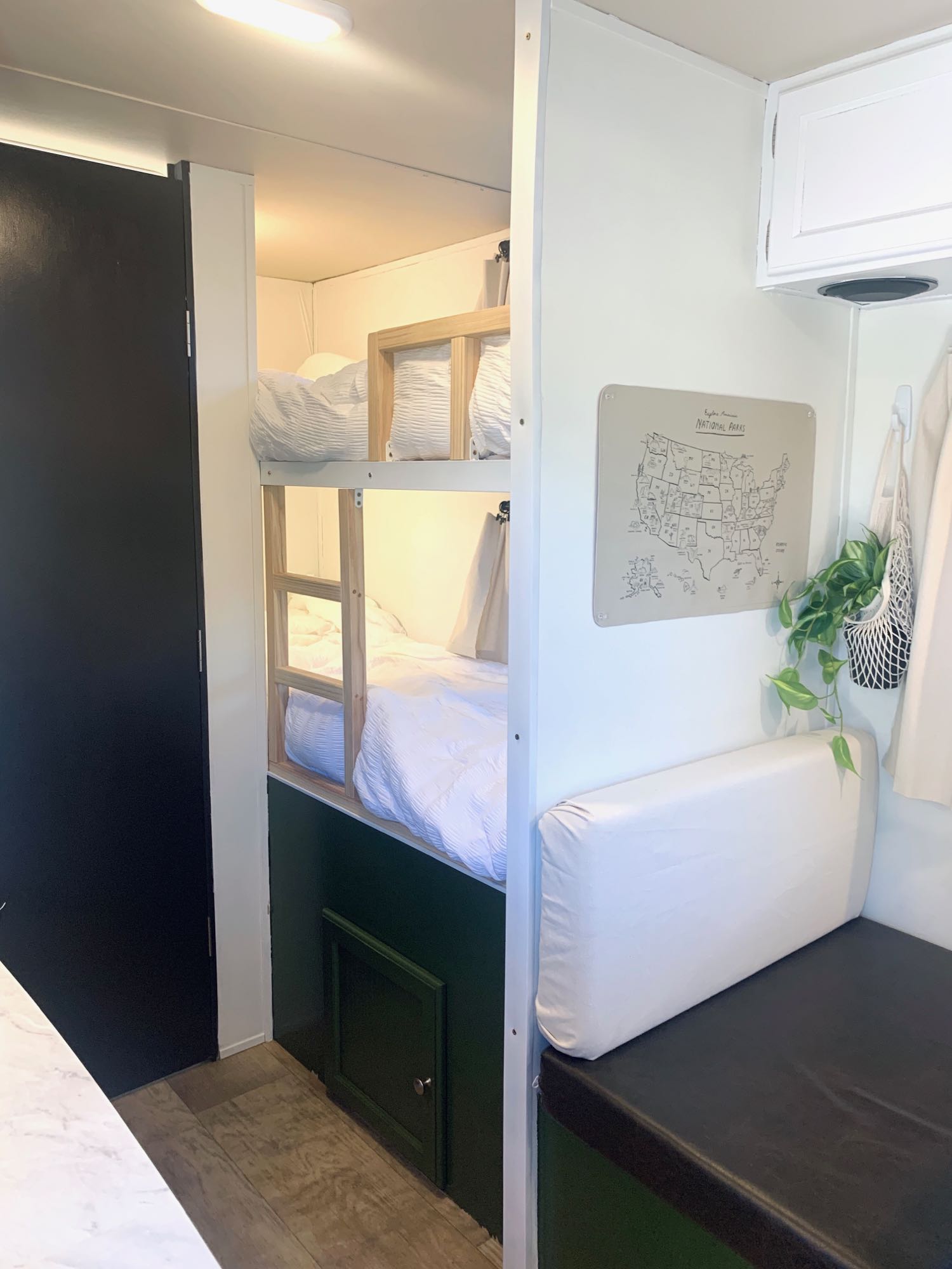 Compact RV rental interior featuring modern bunk beds, a National Parks map, and a comfortable dinette bench.. Palomino Palomini 2016