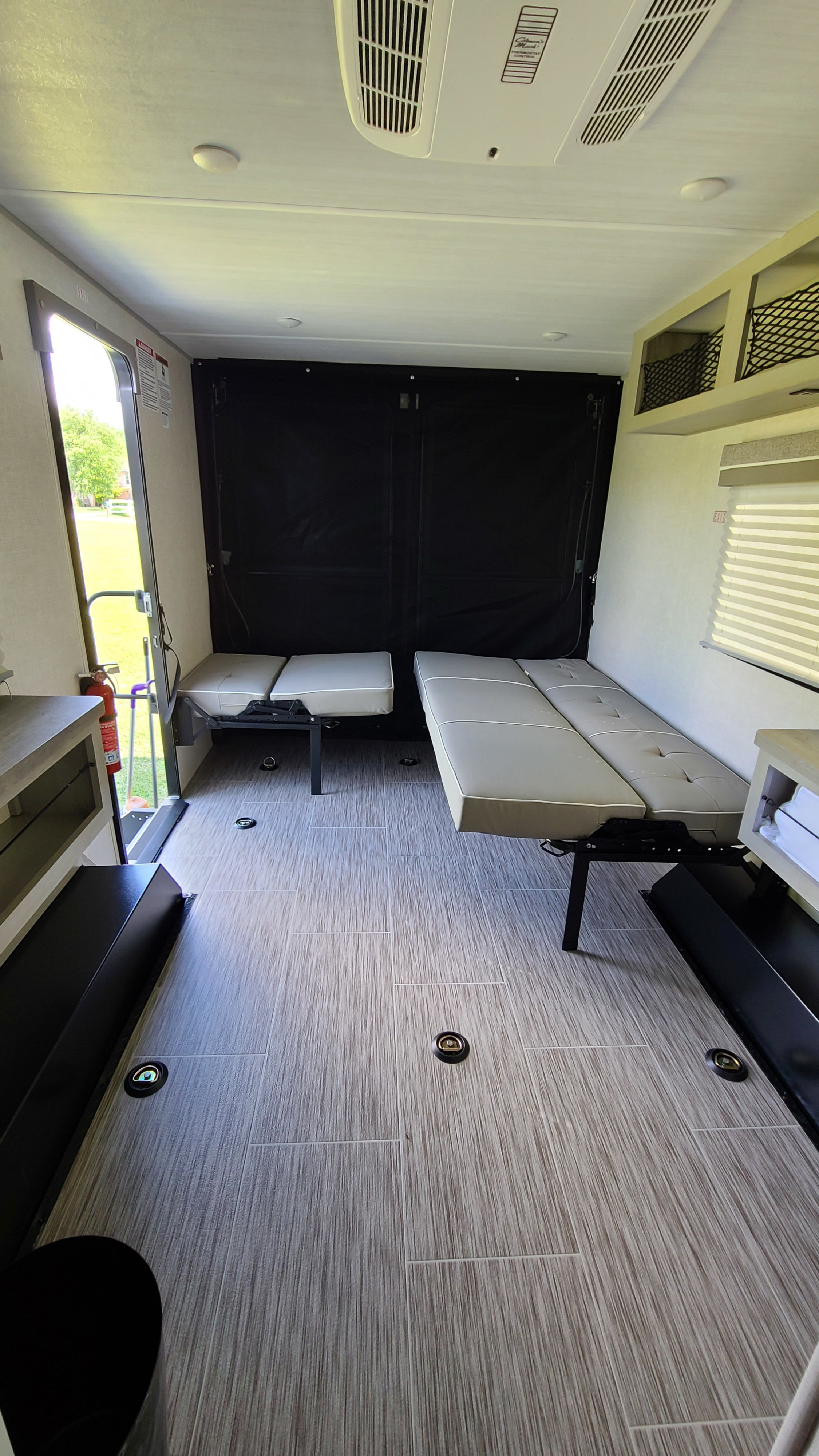RV rental: Versatile toy hauler interior. Features folding beds, floor tie-downs, and an open rear ramp.. Forest River Ibex 2021