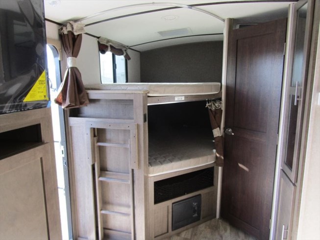 RV rental: Well-lit interior with light wood bunk beds, a ladder, TV, and storage, ideal for family trips.. Forest River Surveyor 2019