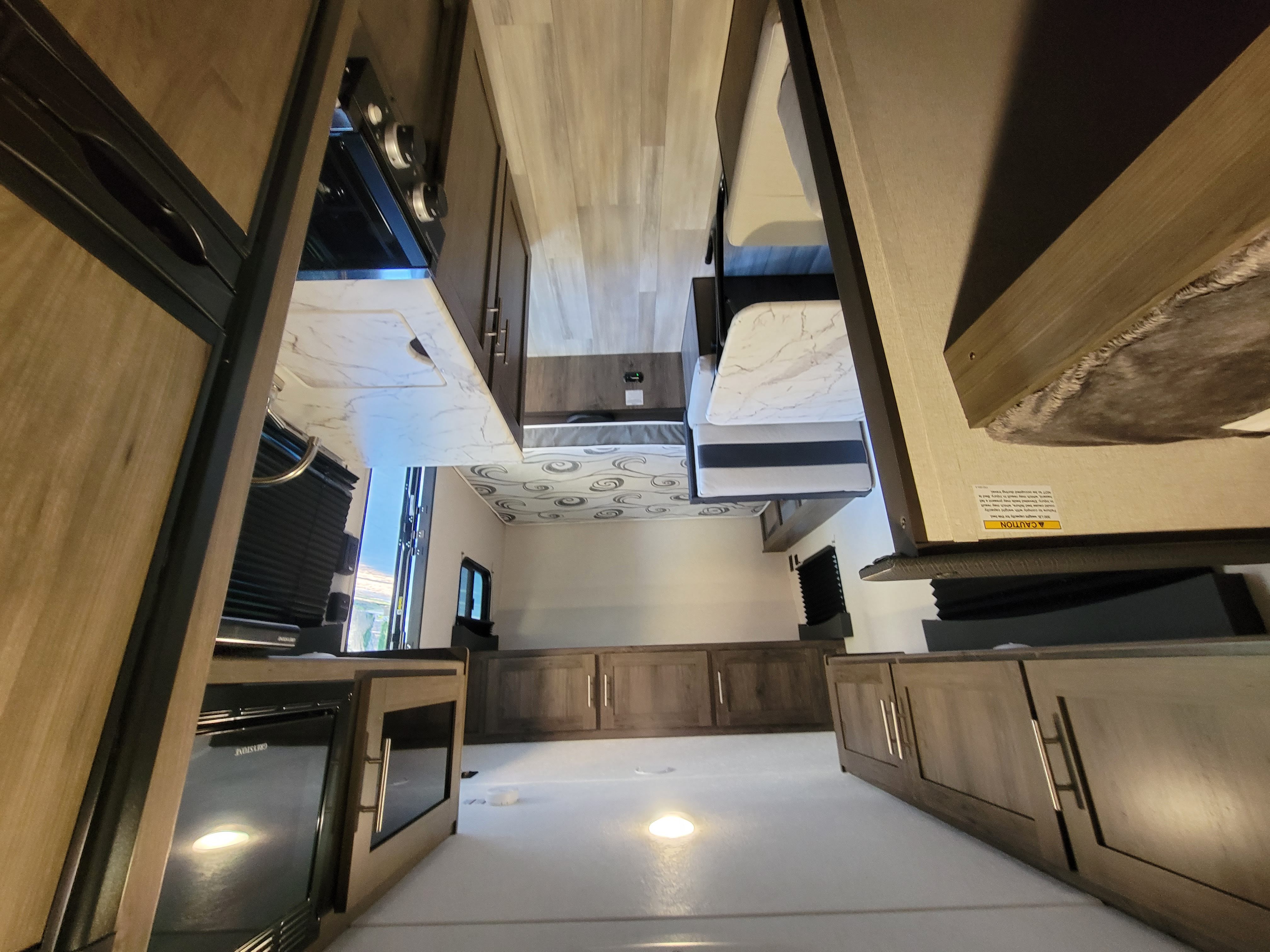Modern RV rental interior: spacious design with a sleek kitchen, appliances, ample storage cabinets, and comfy bunk beds.. Coachmen Clipper 2021
