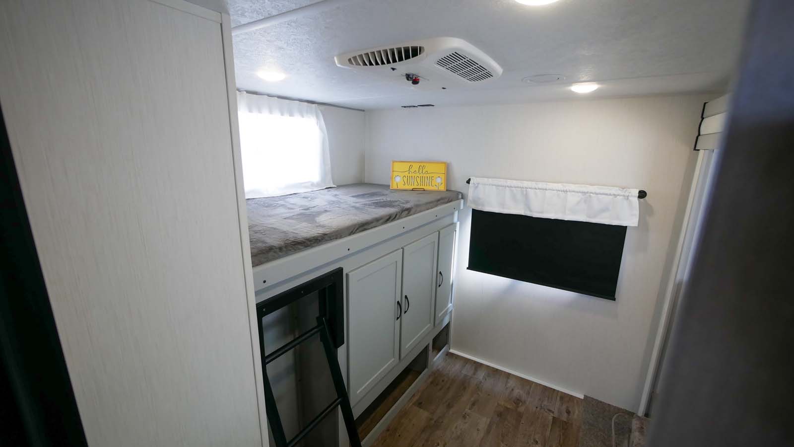 RV rental: View of a bright bunk room with an upper bed, ladder, storage cabinets, window, and AC unit.. Forest River Vibe 2021