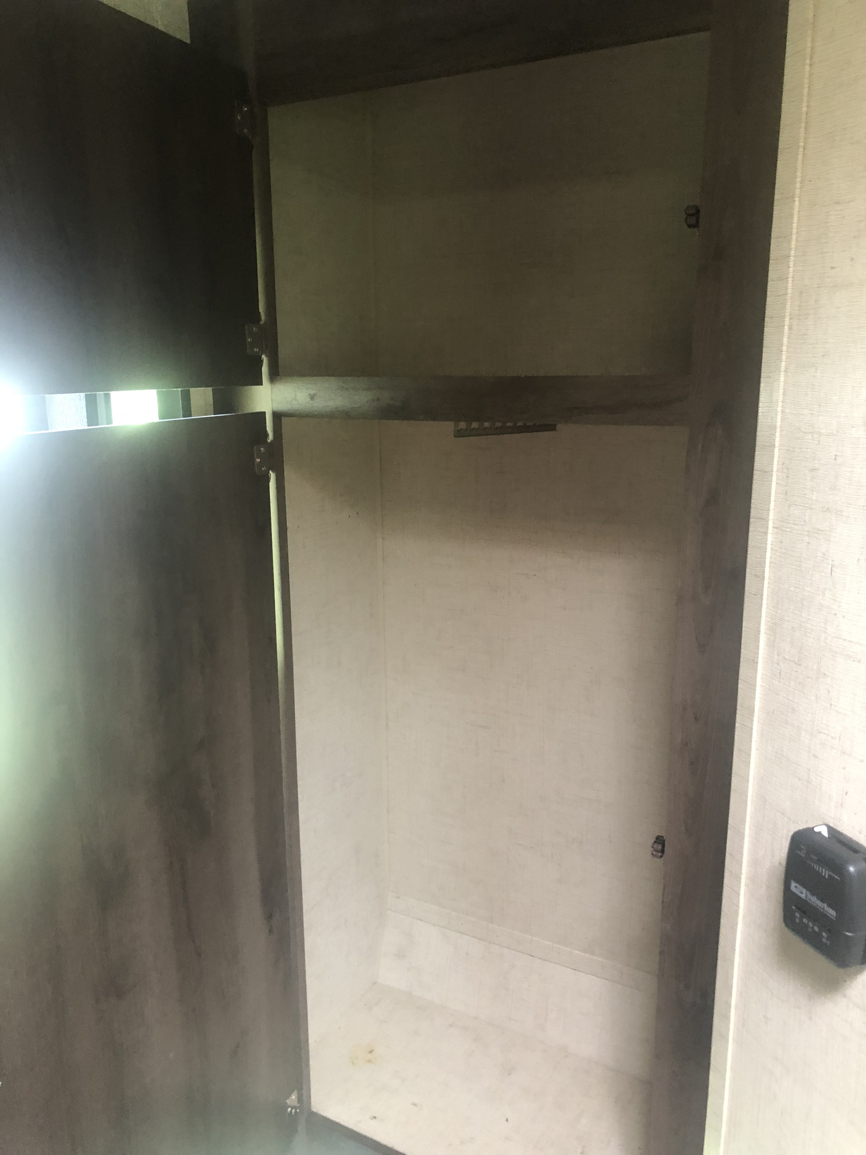 Empty RV rental wardrobe with a shelf and hanging rod, ideal for camper storage space.. K-Z Manufacturing Sportsman Classic 2018