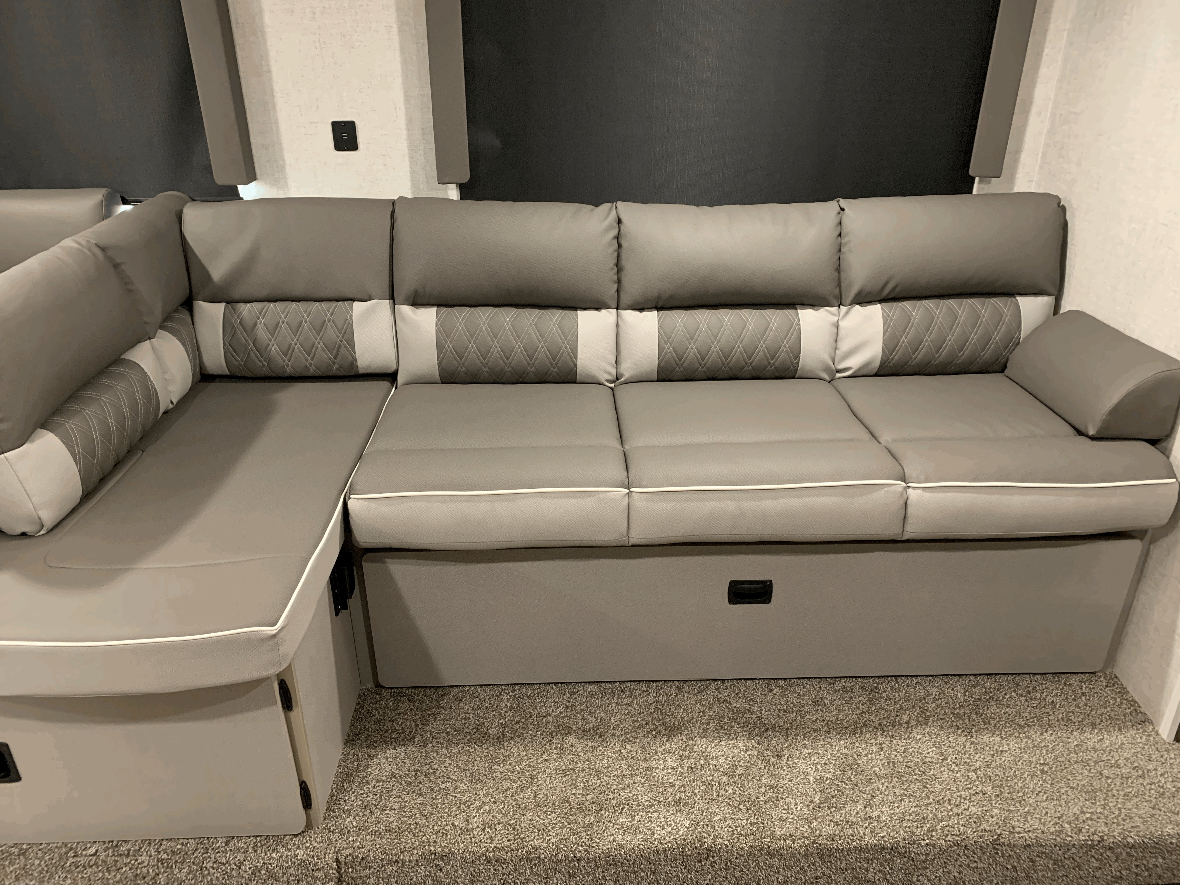 Experience comfort in your RV rental! This image shows a stylish gray L-shaped sofa with storage and quilted accents.. Forest River Salem Cruise Lite 2021