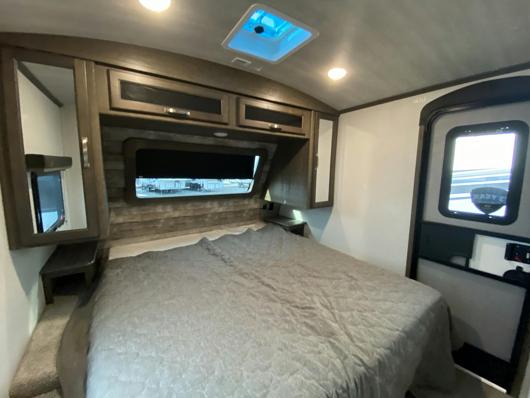 Spacious RV rental bedroom with a comfy bed, overhead storage, window, and skylight. Perfect for a cozy getaway.. Keystone Cougar Half-Ton 2021