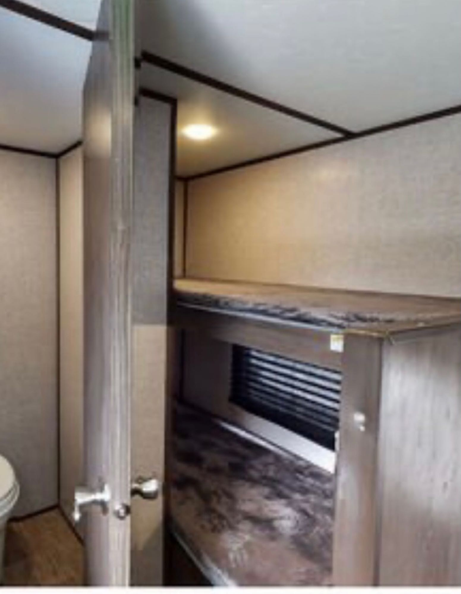 RV rental interior featuring compact bunk beds with a window, and a glimpse of the bathroom area through an open door.. Coleman COLEMAN LANTERN 2021