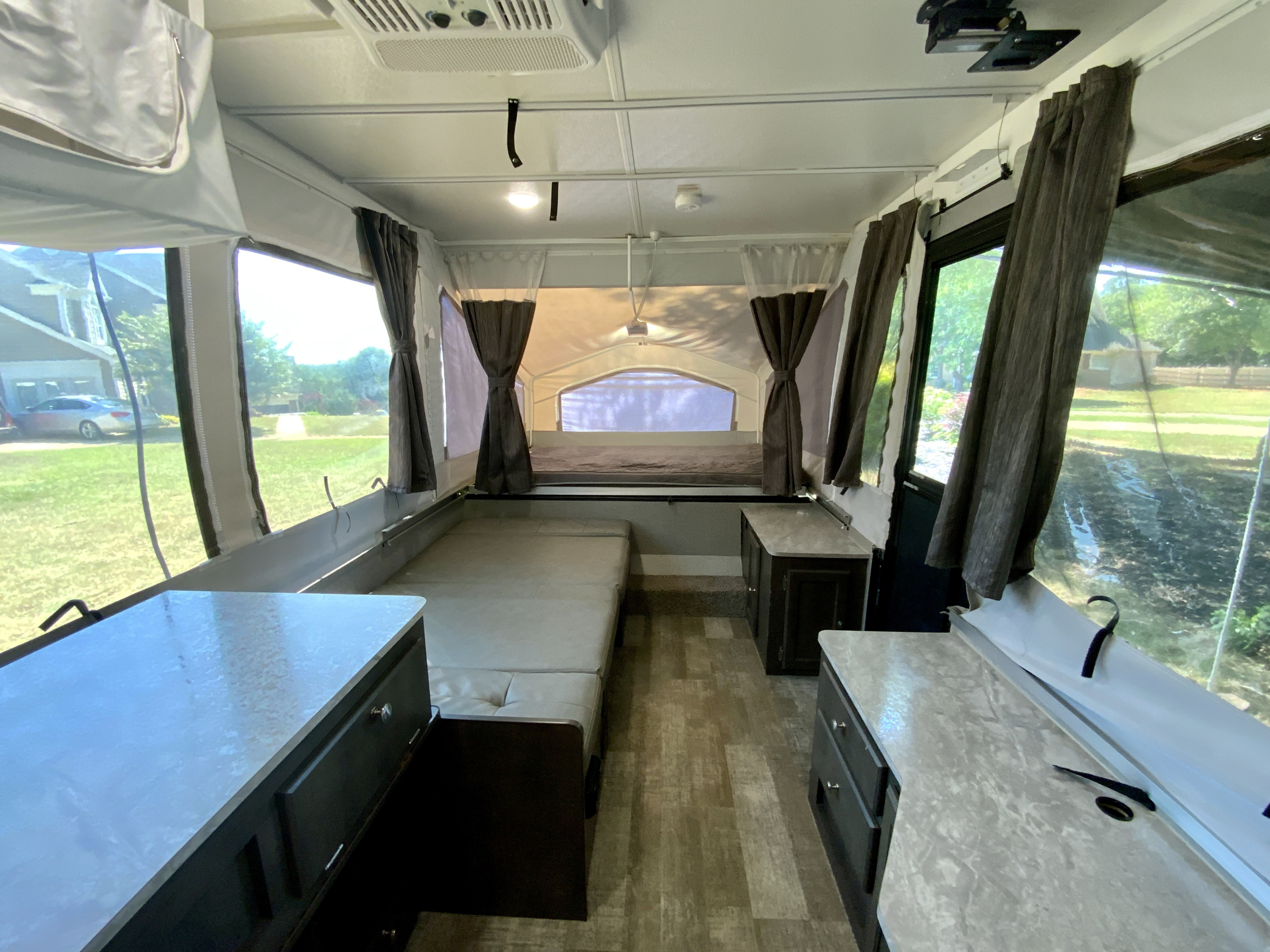 Spacious pop-up RV rental interior: beds, kitchenette counters, and wood-look flooring visible. Ready for your adventure!. Forest River Rockwood Freedom 2020